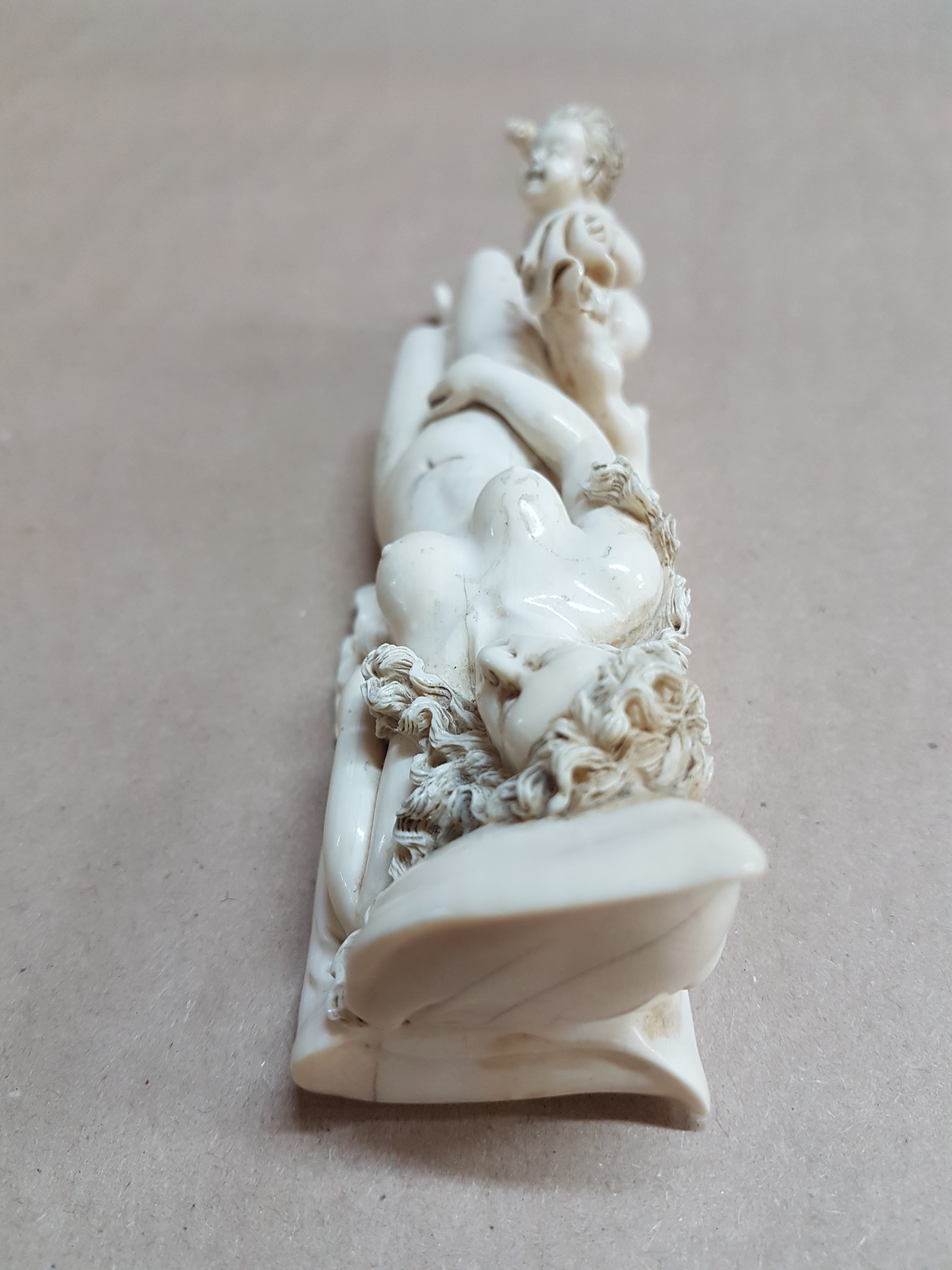 Detail h: Elfenbeinfigur, wohl flämisch, 17./18. Jh., liegende Venus mit Amor, die Göttin hat ihren Kopf auf einem Kissen liegen, mit einer Hand verdeckt sie ...
