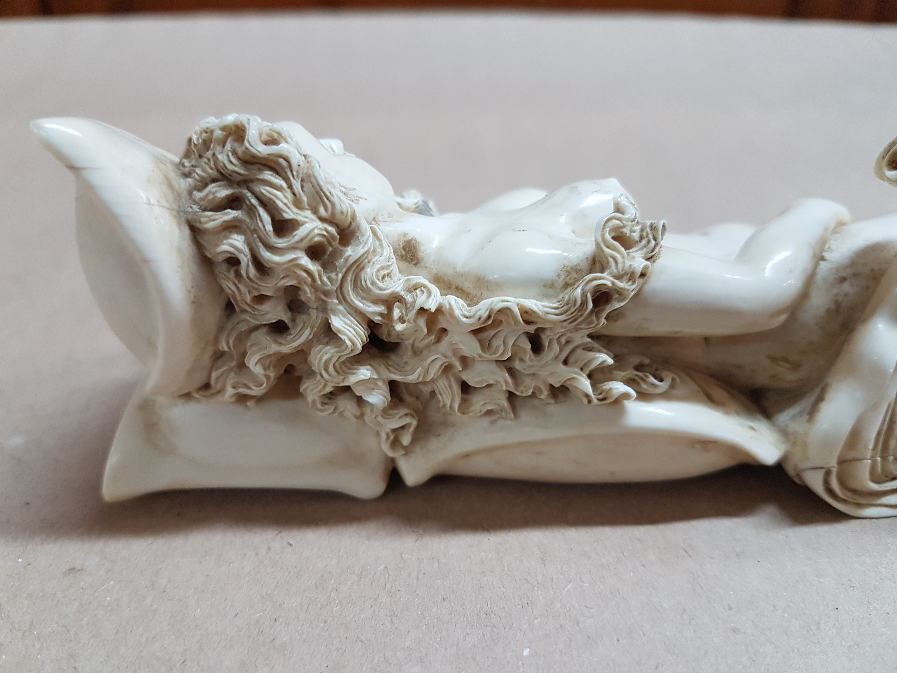 Detail j: Elfenbeinfigur, wohl flämisch, 17./18. Jh., liegende Venus mit Amor, die Göttin hat ihren Kopf auf einem Kissen liegen, mit einer Hand verdeckt sie ...