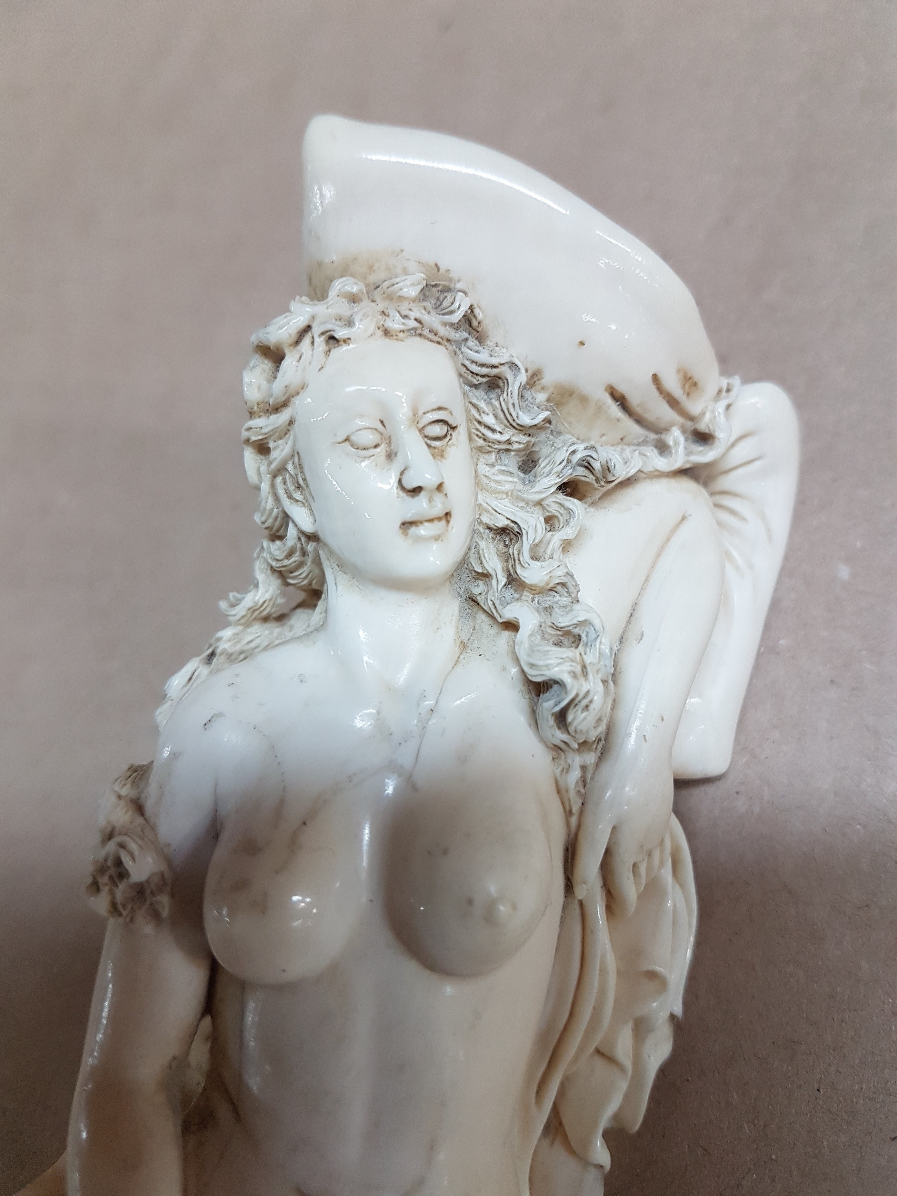 Detail m: Elfenbeinfigur, wohl flämisch, 17./18. Jh., liegende Venus mit Amor, die Göttin hat ihren Kopf auf einem Kissen liegen, mit einer Hand verdeckt sie ...