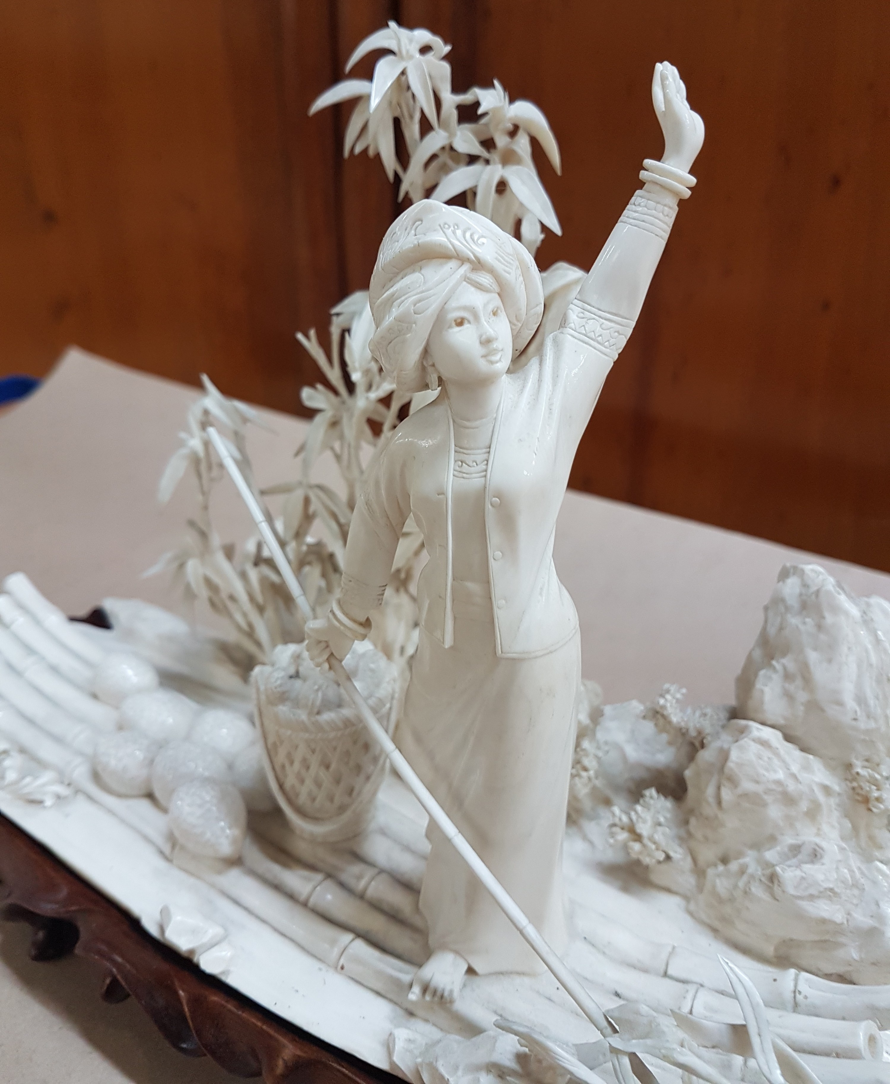Detail e: Elfenbeinschnitzerei, China um 1900, Obstverkäuferin auf Floß, junge Frau mit erhobenem Arm und Stange, dahinter felsige Landschaft mit Bambus, ...