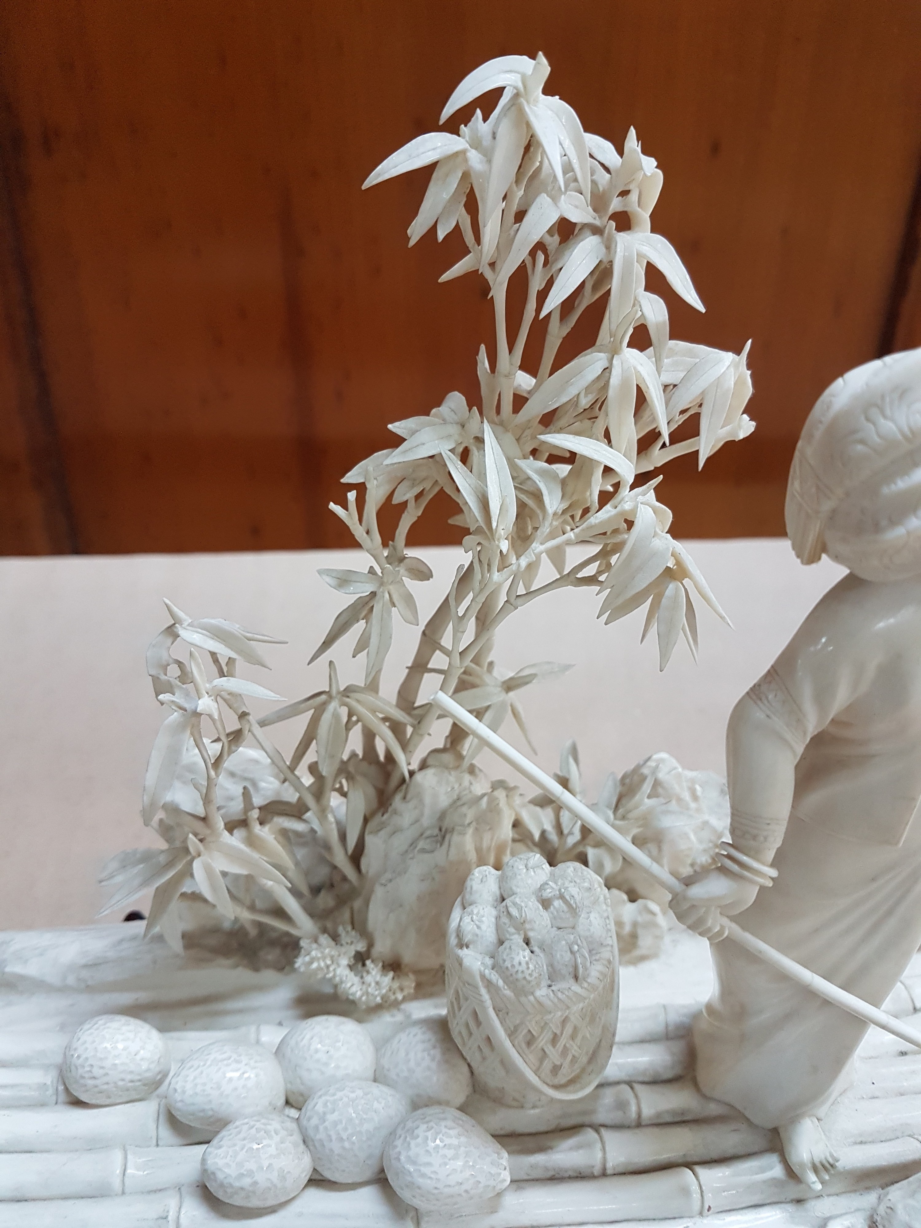 Detail g: Elfenbeinschnitzerei, China um 1900, Obstverkäuferin auf Floß, junge Frau mit erhobenem Arm und Stange, dahinter felsige Landschaft mit Bambus, ...