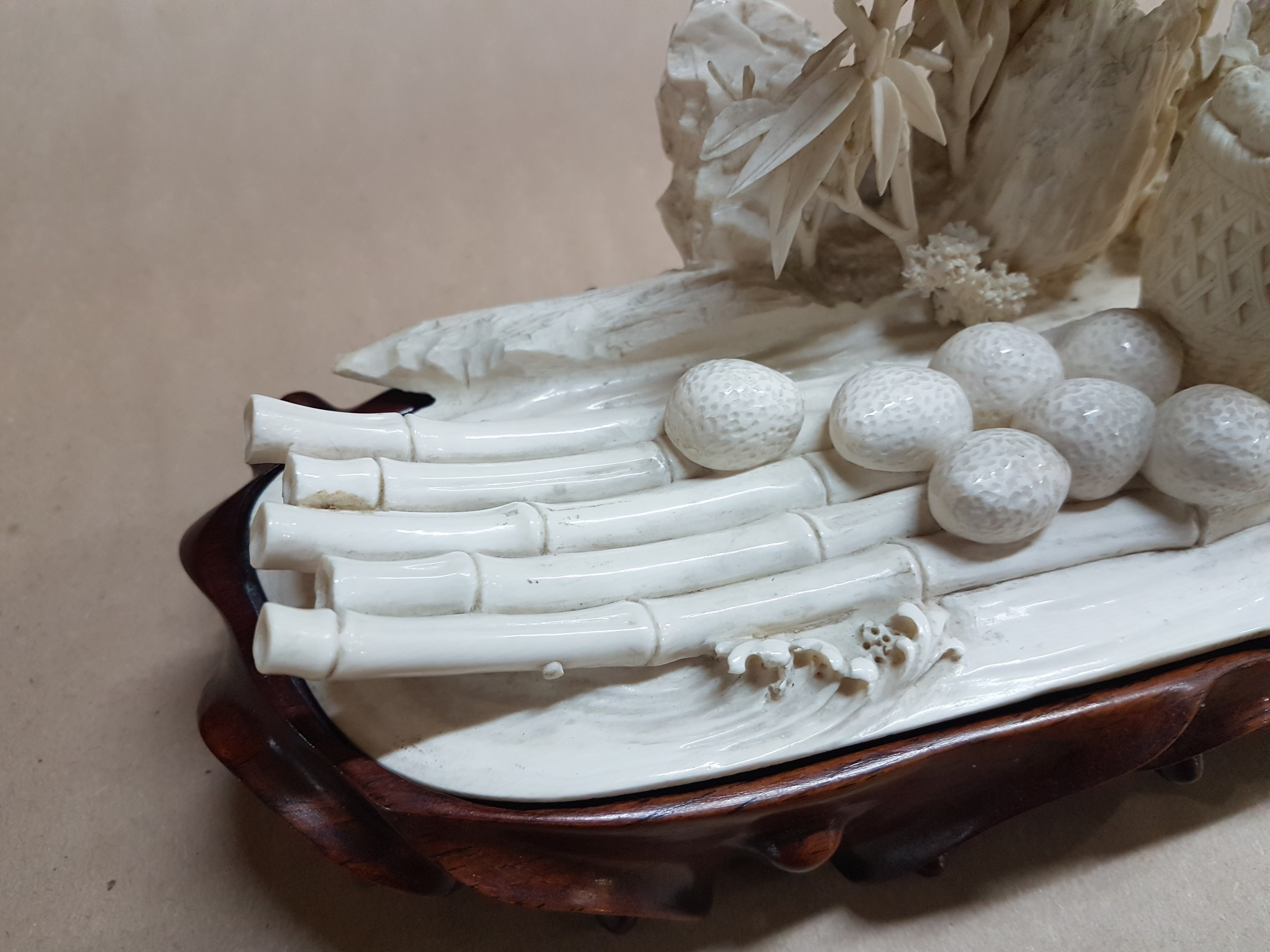 Detail h: Elfenbeinschnitzerei, China um 1900, Obstverkäuferin auf Floß, junge Frau mit erhobenem Arm und Stange, dahinter felsige Landschaft mit Bambus, ...