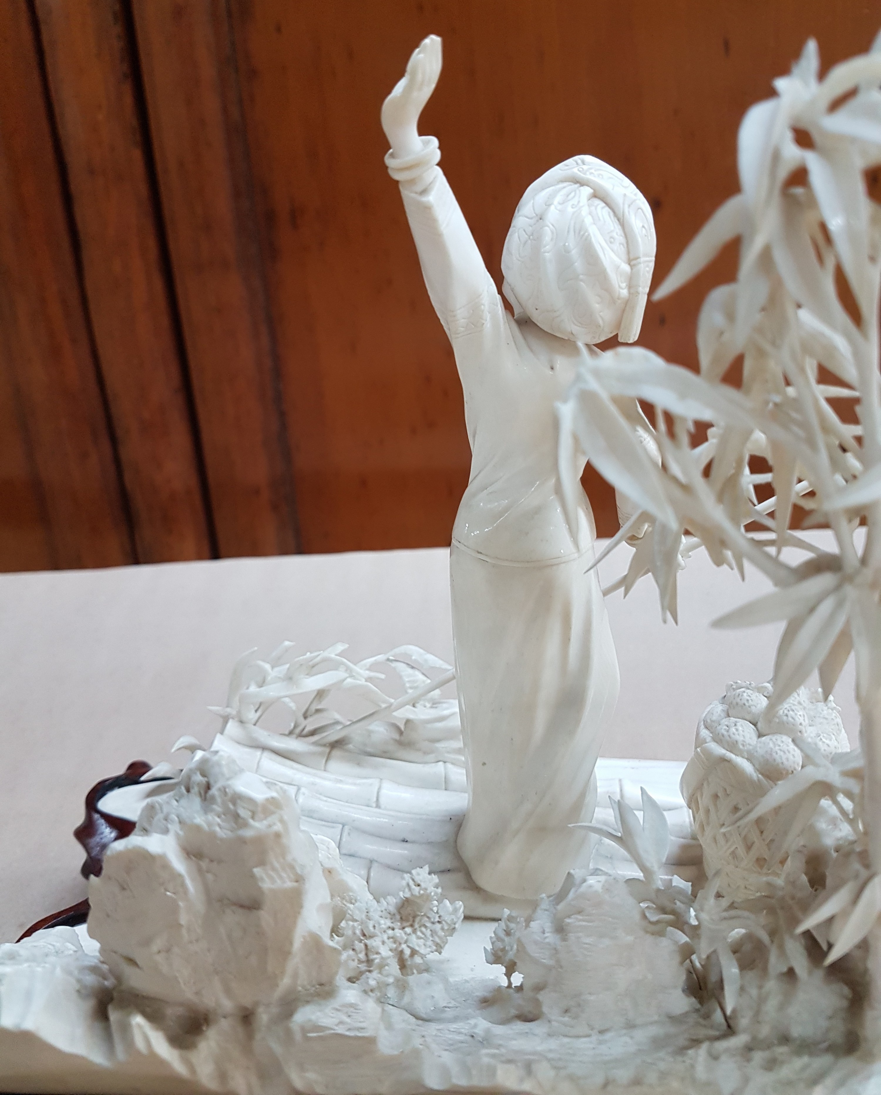 Detail j: Elfenbeinschnitzerei, China um 1900, Obstverkäuferin auf Floß, junge Frau mit erhobenem Arm und Stange, dahinter felsige Landschaft mit Bambus, ...