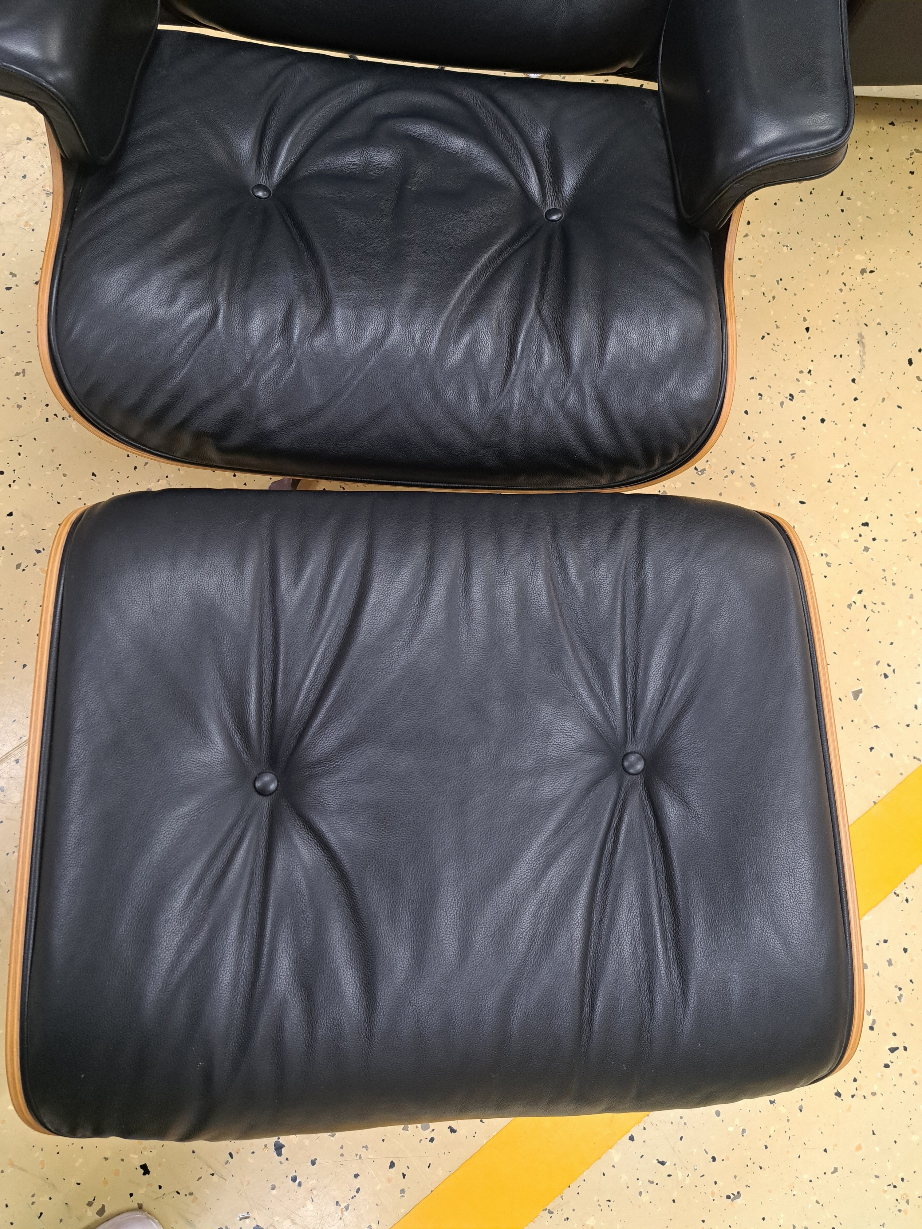 Detail c: Lounge-Chair mit Ottomane, Entw. Charles & Ray Eames von 1956, Ausführung Vitra, Sitzschale aus Schichtholz, Polsterung mit schwarzem Lederbezug, ...