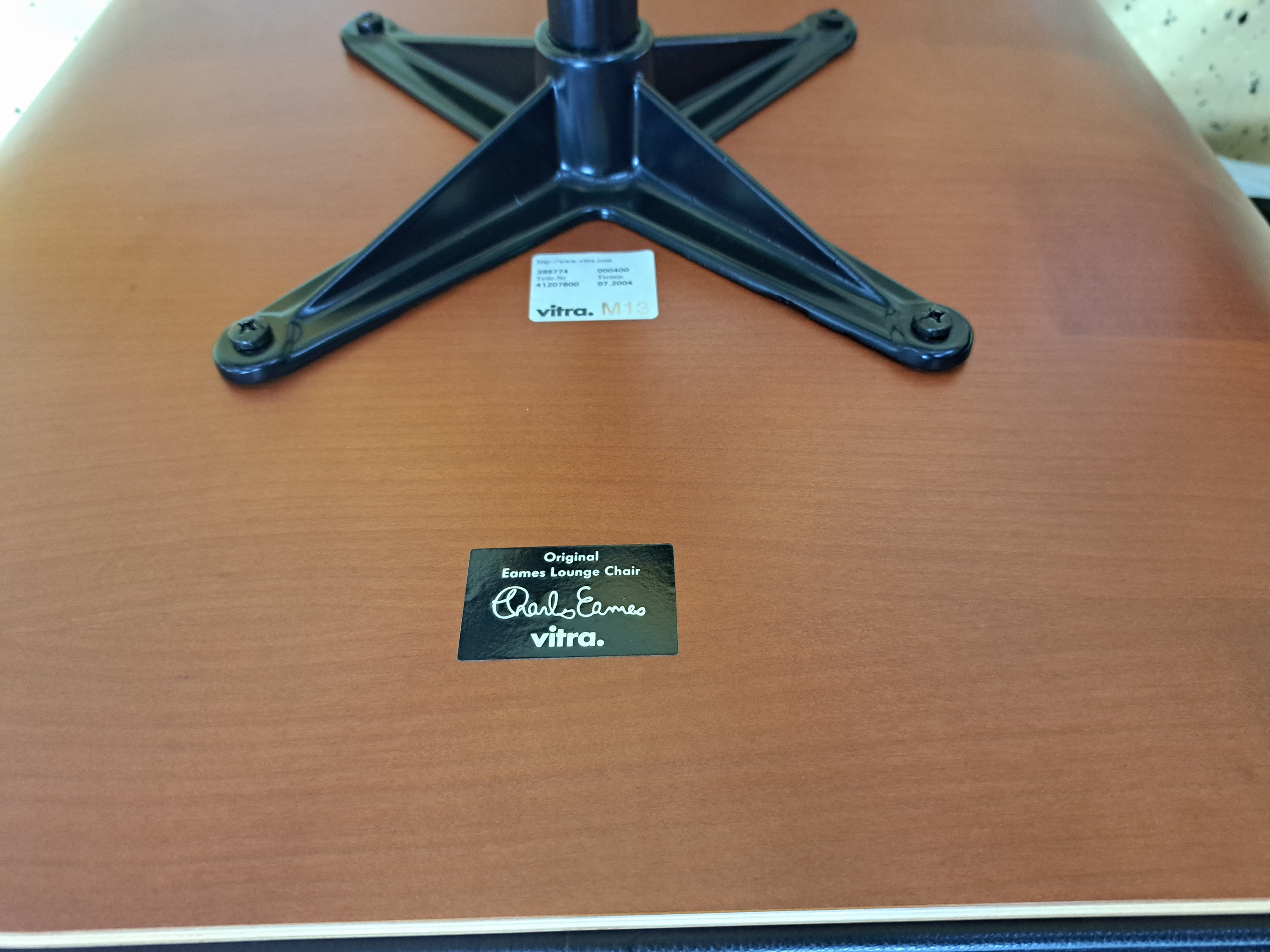 Detail e: Lounge-Chair mit Ottomane, Entw. Charles & Ray Eames von 1956, Ausführung Vitra, Sitzschale aus Schichtholz, Polsterung mit schwarzem Lederbezug, ...