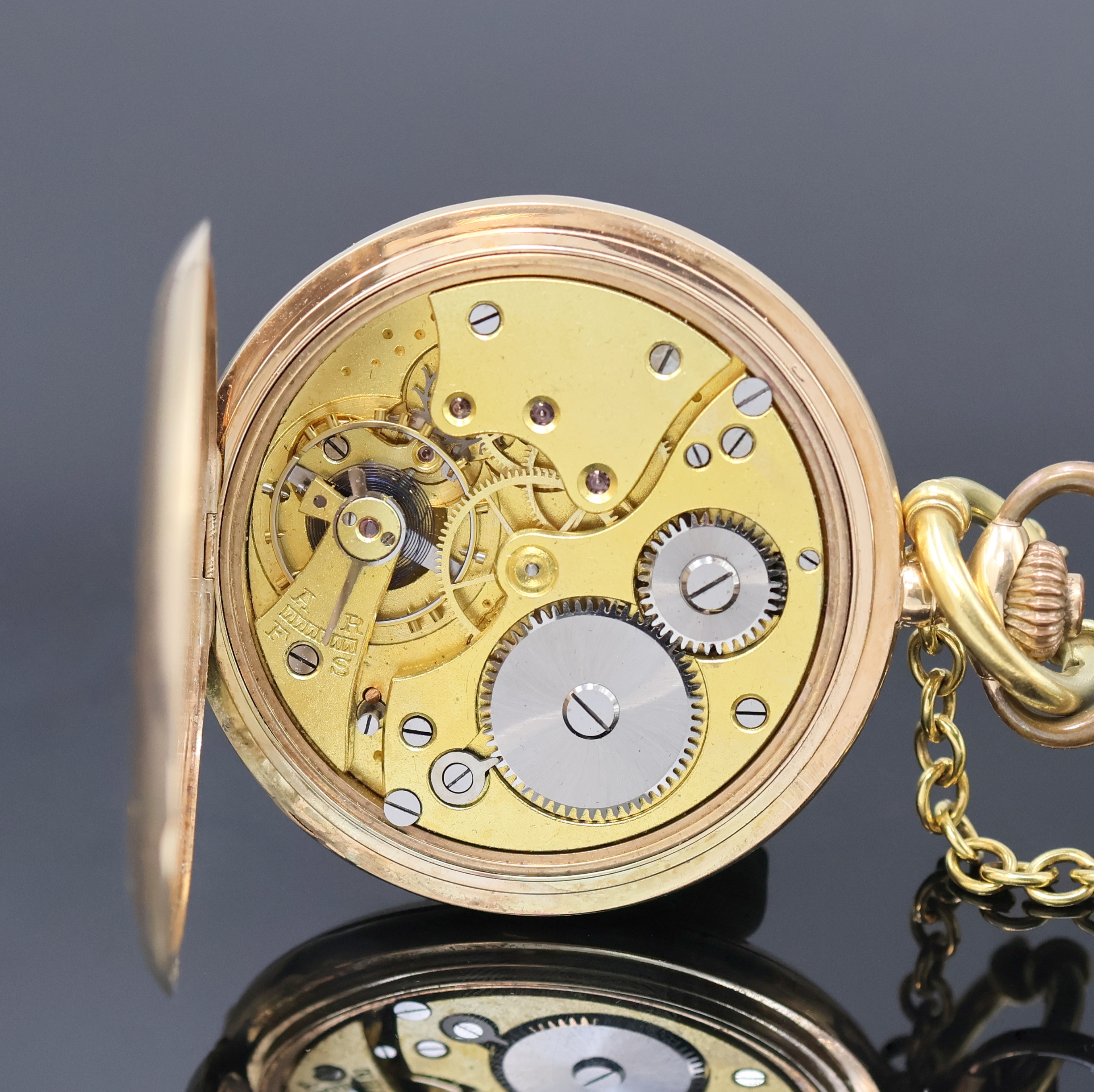 Detail e: Herrensavonette in RG 585/000 mit vergoldeter Kette, Schweiz um 1925, guill. Geh. dell., Metallcuvette sowie Innengeh. m. Widmung, Emailzifferbl. m. ...