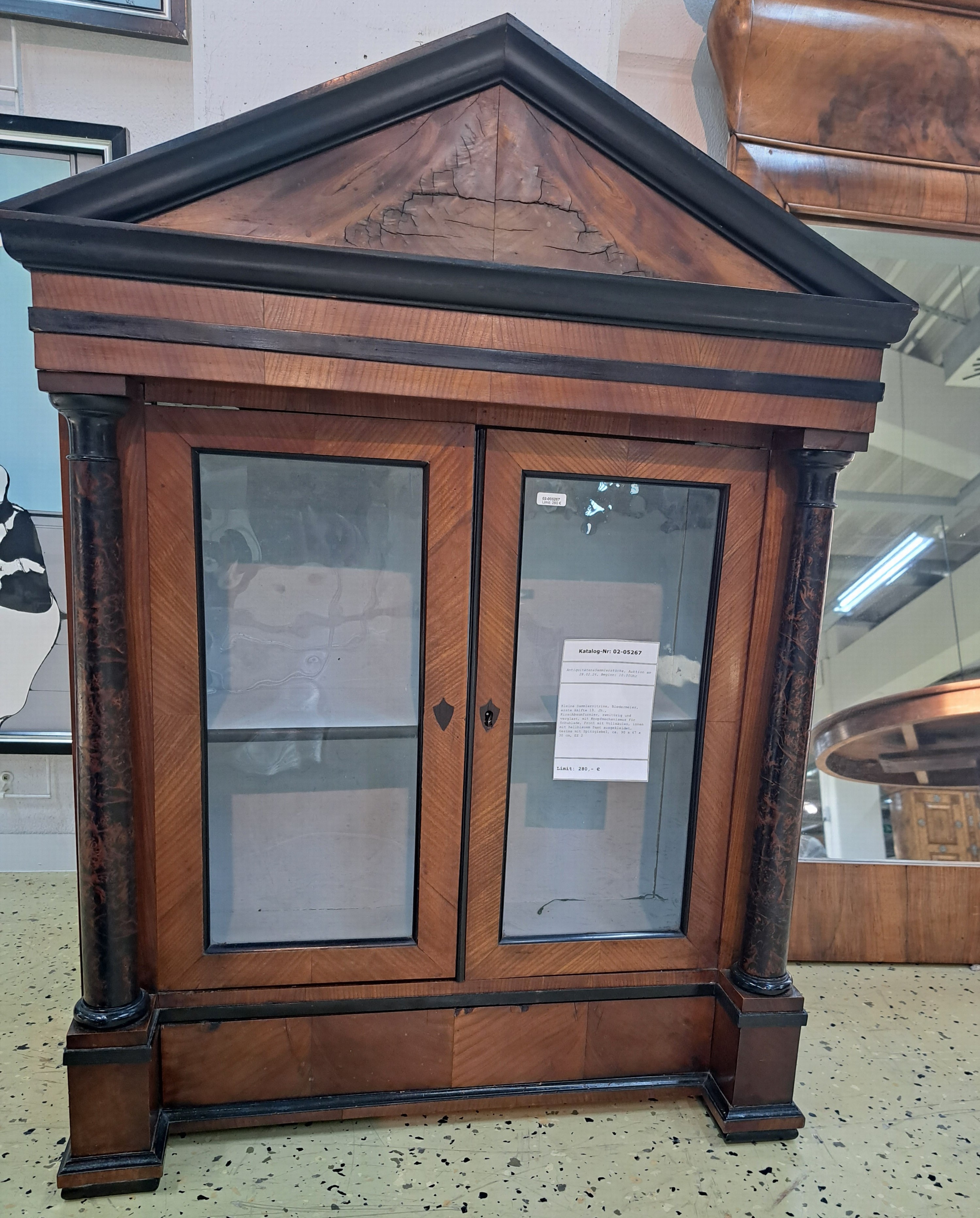 Detail c: Kleine Sammlervitrine, Biedermeier, erste Hälfte 19. Jh., Kirschbaumfurnier, zweitürig und verglast, mit Knopfmechanismus für Schublade, Front mit ...