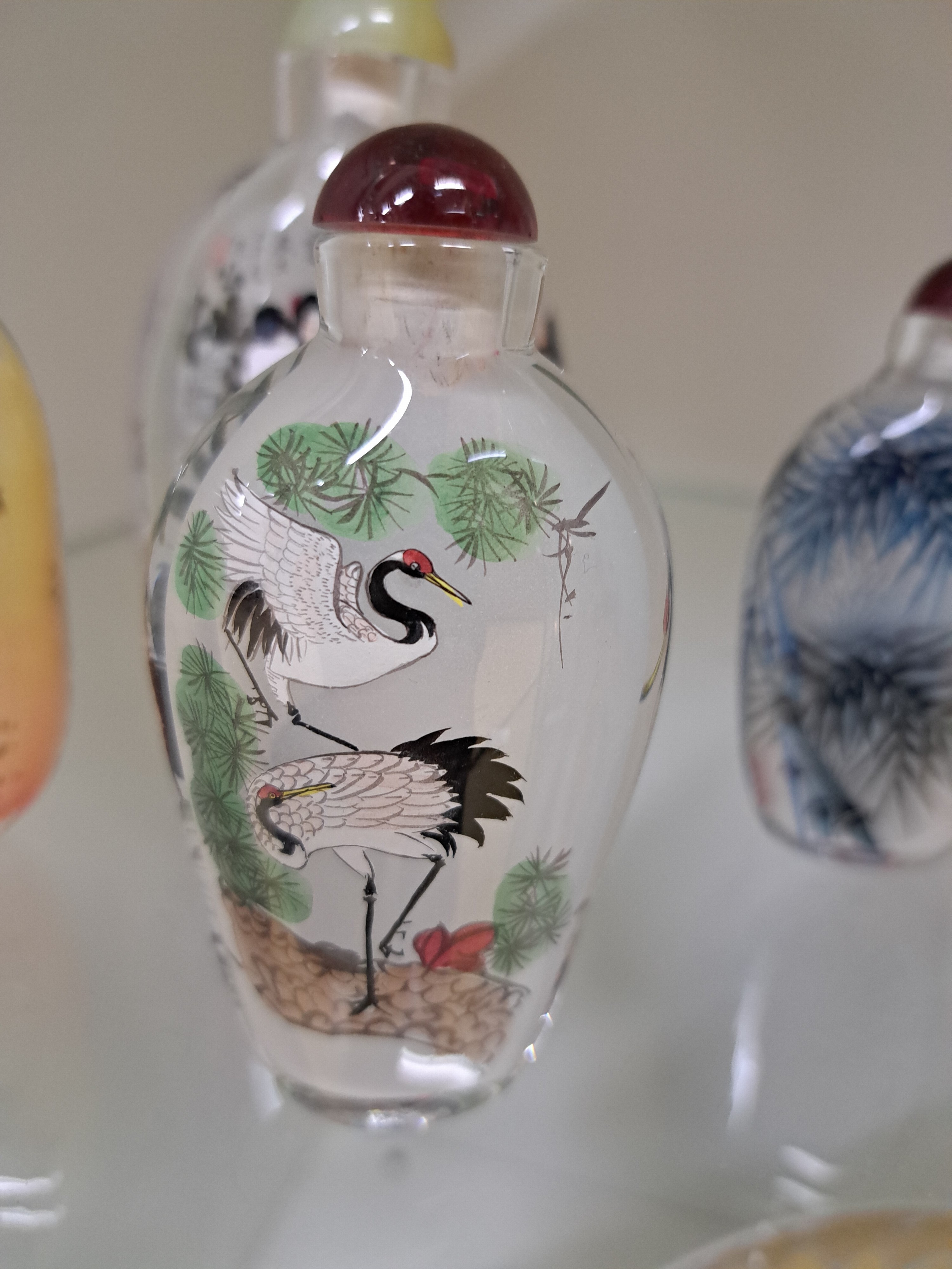 Detail b: Vier Snuff-Bottles, China, 20. Jh., Glas, innen mit feiner Handmalerei, Reiher, Bambus, Damen in Parklandschaft, 9-12 cm