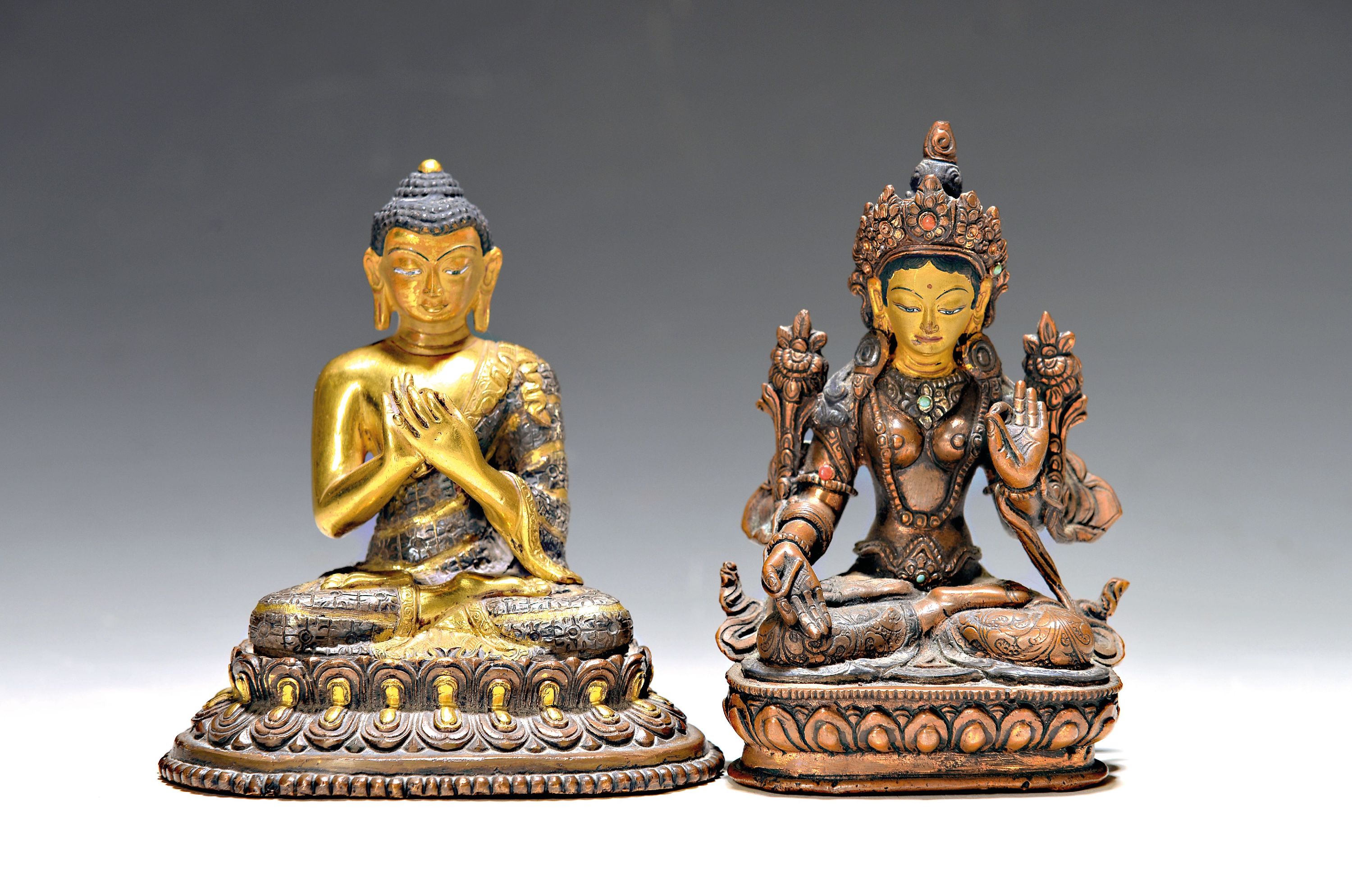Zwei Buddhas, Nepal/Tibet, 20. Jh., Bronze: Tara, mit Steinbesatz, bemalt, H. ca. 14 cm u. Buddha, Dharmachakra, z.T. versilbert, aufwendiges Gewand, ...