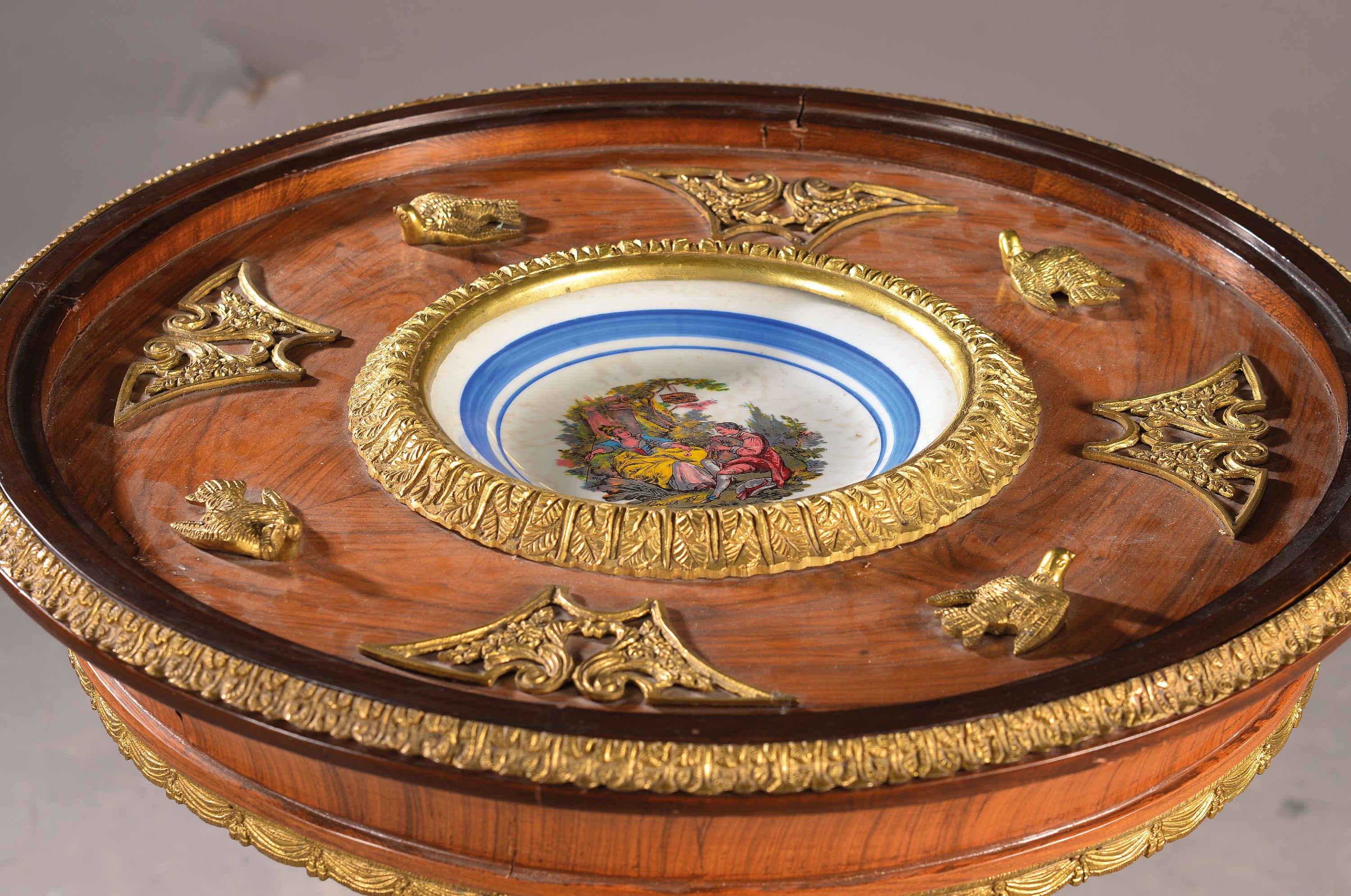 Detail a: Tisch mit eingelassenem Teller, Frankreich, 19.Jh., Nußbaumfurnier, aufwendige Messingapplikationen in form von Adlern, H. ca. 80 cm, D. ca. 67 cm, ...