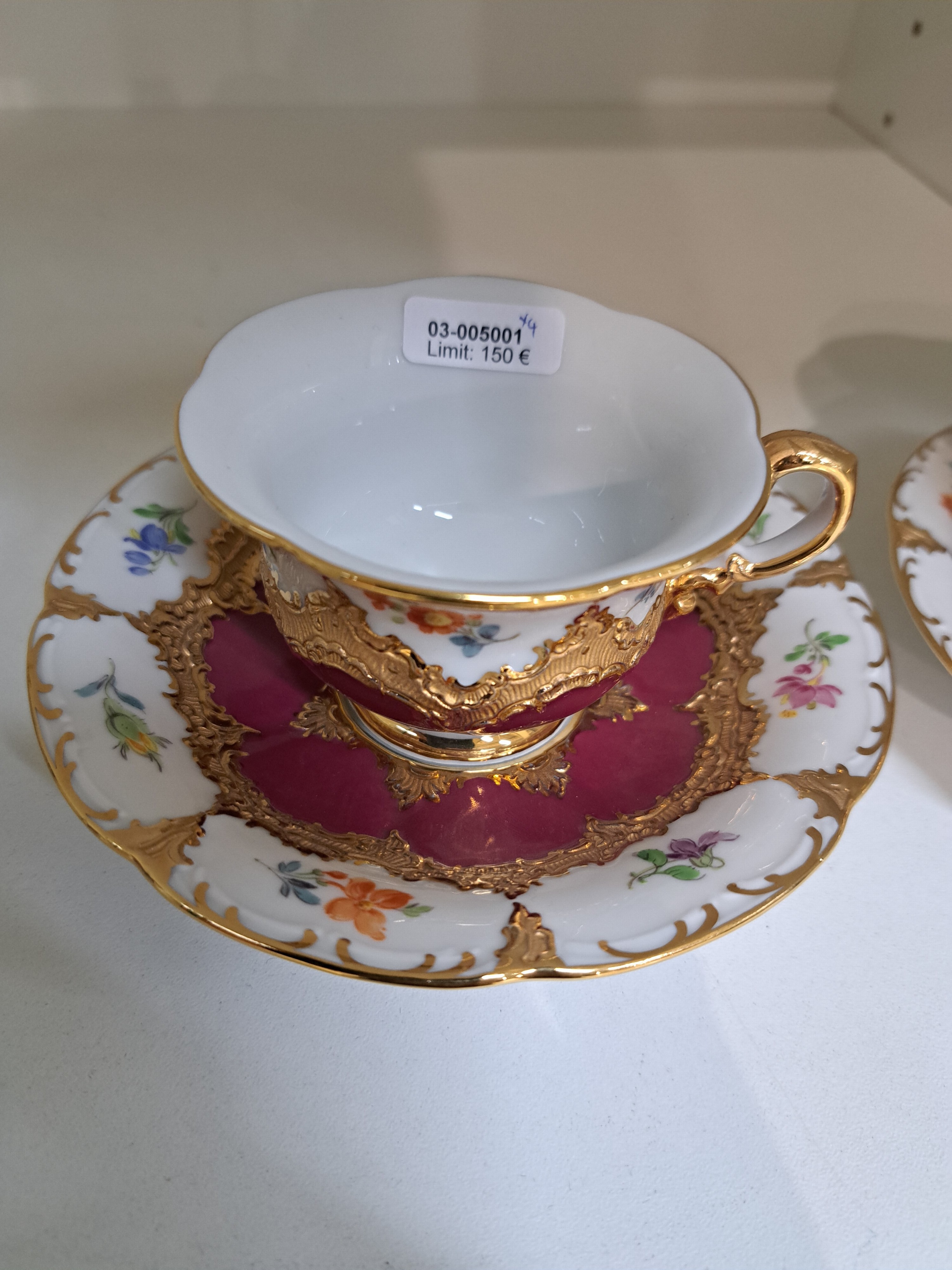 Detail a: Zwei Mokkatassen mit Untertassen, Meissen, 2.H.20.Jh., B-Form, purpurroter Fond, bemalt im Dekor gestreute Blümchen, Matt- u. Glanzvergoldung, 2. ...