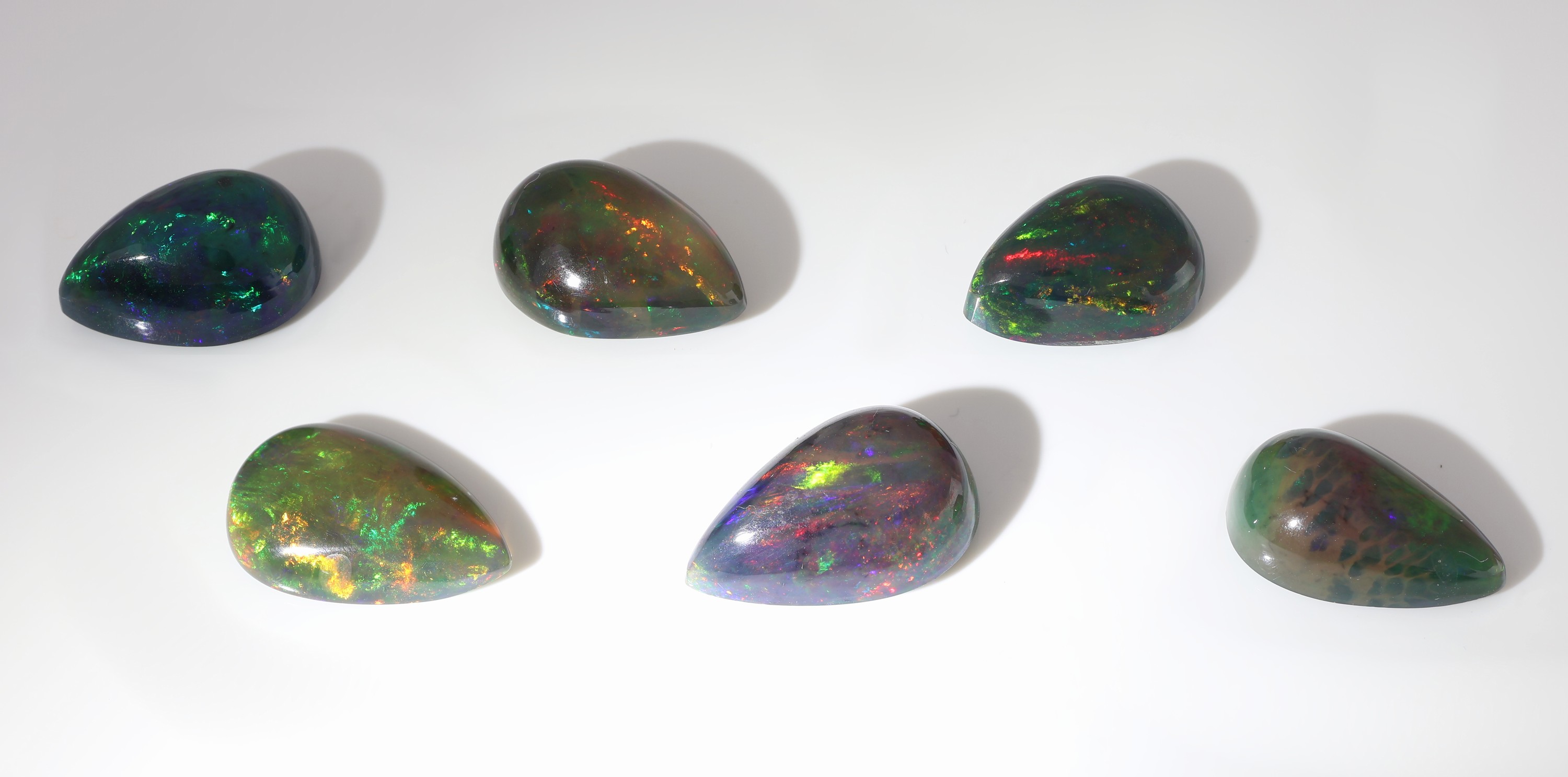 Detail b: Lot 6 lose schwarze Opale, zus. ca. 16.36 ct, tropfenf. Cabochons in versch. Größen, intensives Farbspiel