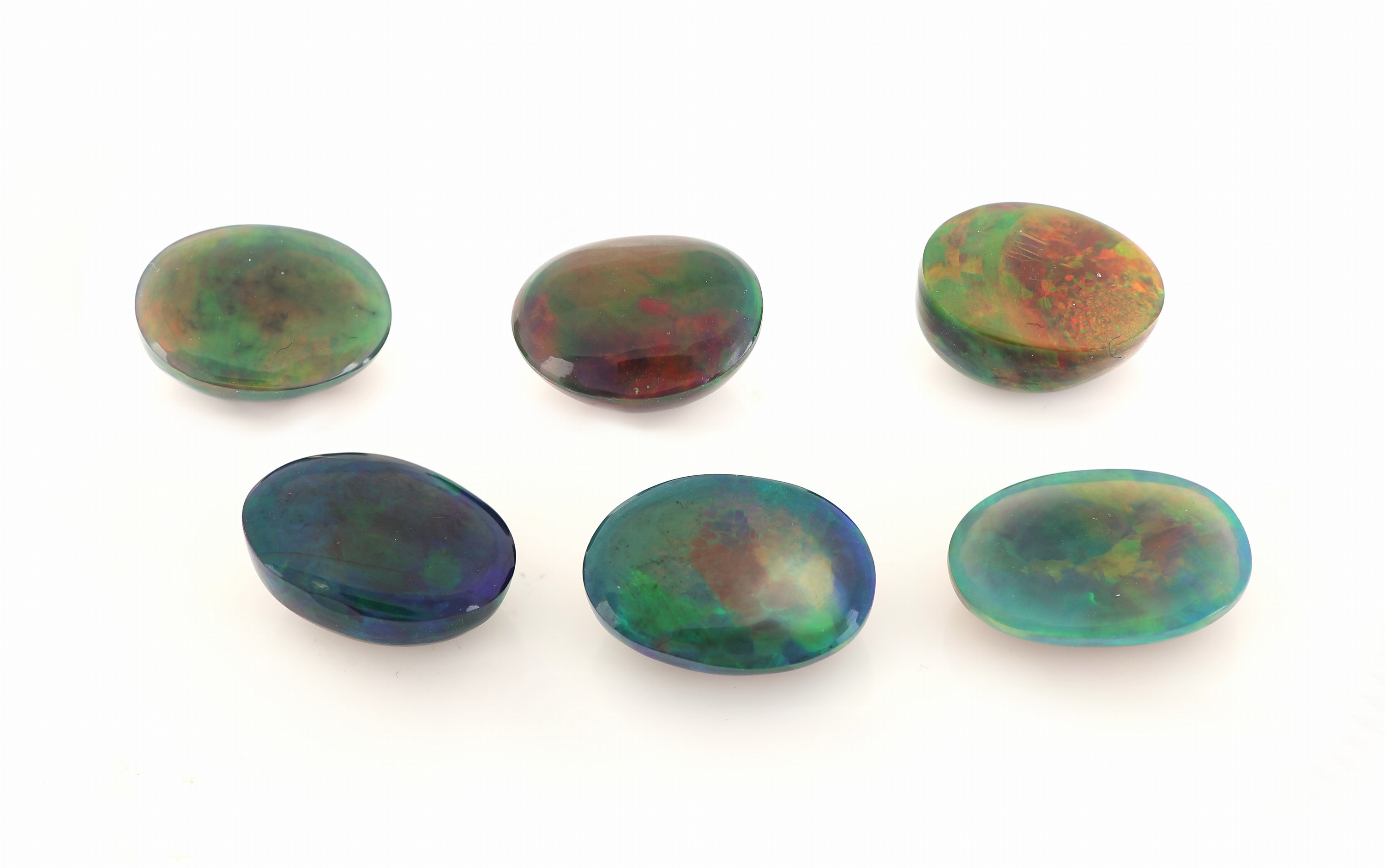 Detail a: Lot 6 lose schwarze Opale, zus. ca. 18.93 ct, ovale Cabochons in versch. Größen, intensives Farbspiel
