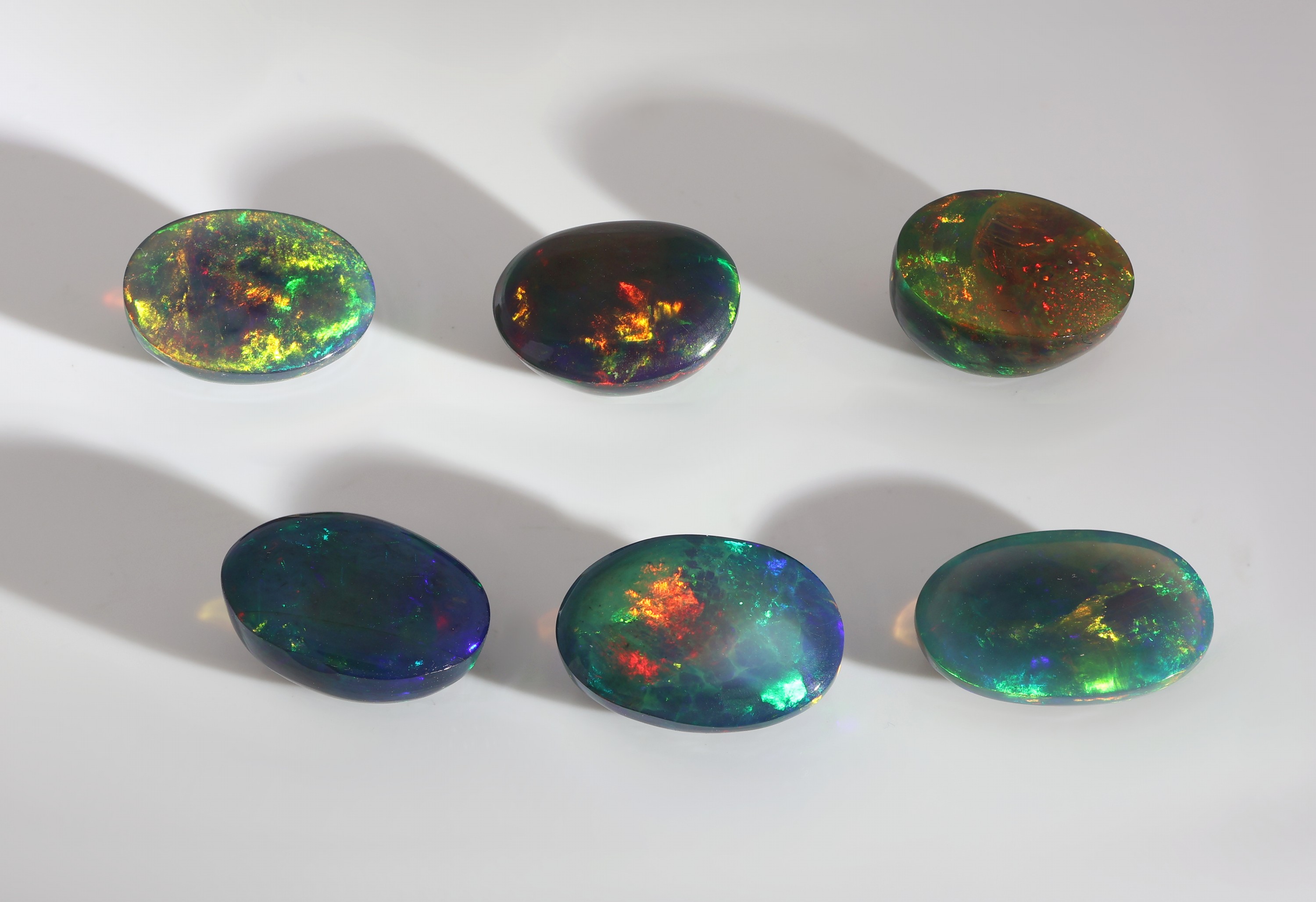 Detail c: Lot 6 lose schwarze Opale, zus. ca. 18.93 ct, ovale Cabochons in versch. Größen, intensives Farbspiel