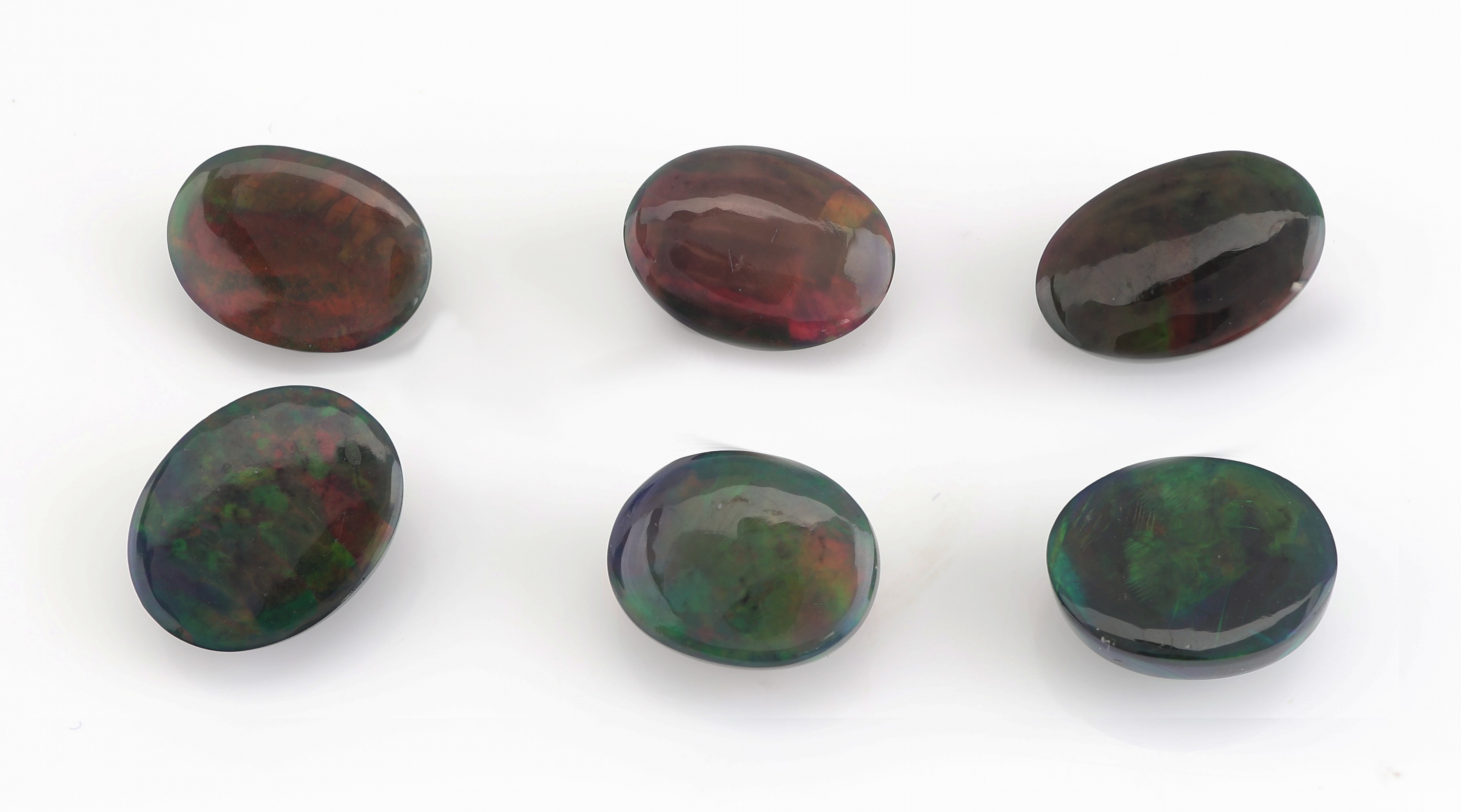 Detail a: Lot 6 lose schwarze Opale, zus. ca. 20.71 ct, ovale Cabochons in versch. Größen, intensives Farbspiel