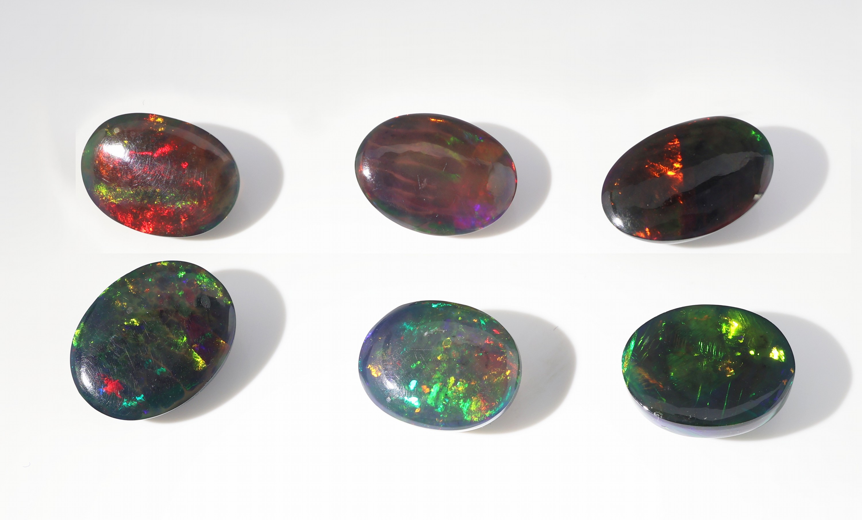 Detail b: Lot 6 lose schwarze Opale, zus. ca. 20.71 ct, ovale Cabochons in versch. Größen, intensives Farbspiel