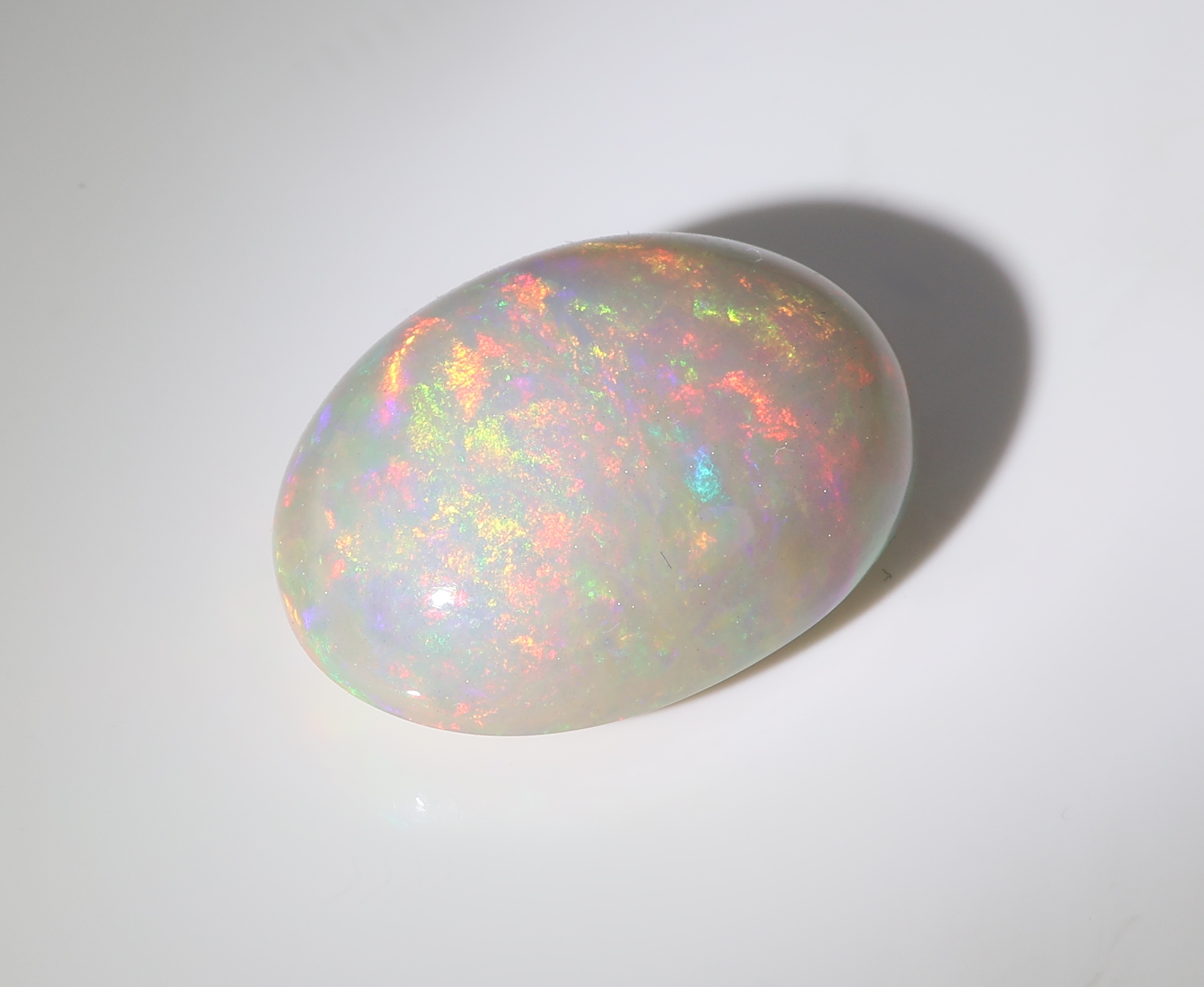Detail b: Loser weißer Opal, ca. 10.97 ct, ovaler Cabochon, Farbspiel in Blau, Rot und Grün, ca.18.81 x 14.05 x 8.18 mm, Herkunft Äthiopien