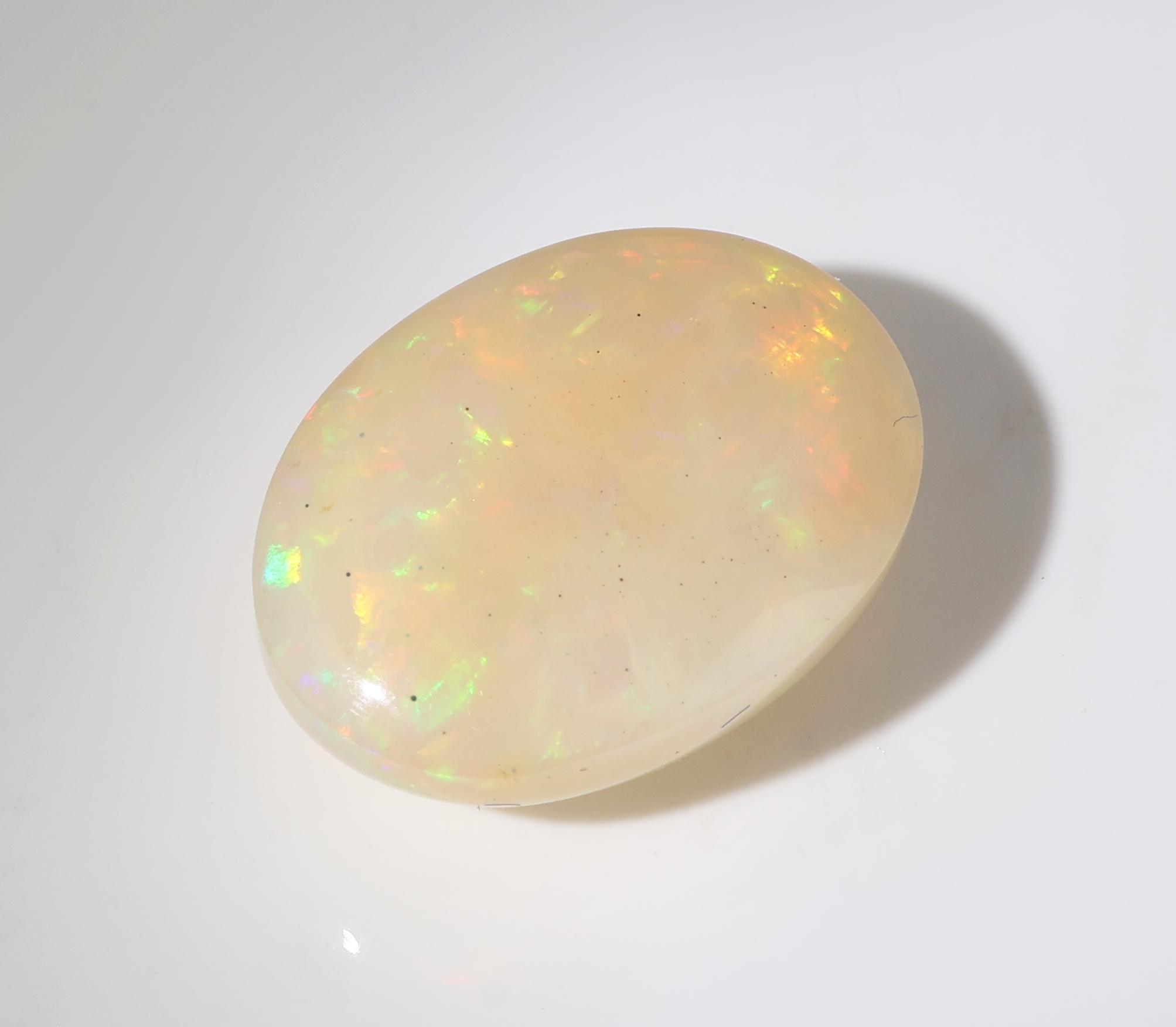 Detail c: Loser weißer Opal, ca. 9.52 ct, ovaler Cabochon, Farbspiel in Grün, Gelb und Blau, ca. 17.31 x 12.99 x 7.33 mm, Herkunft Äthiopien