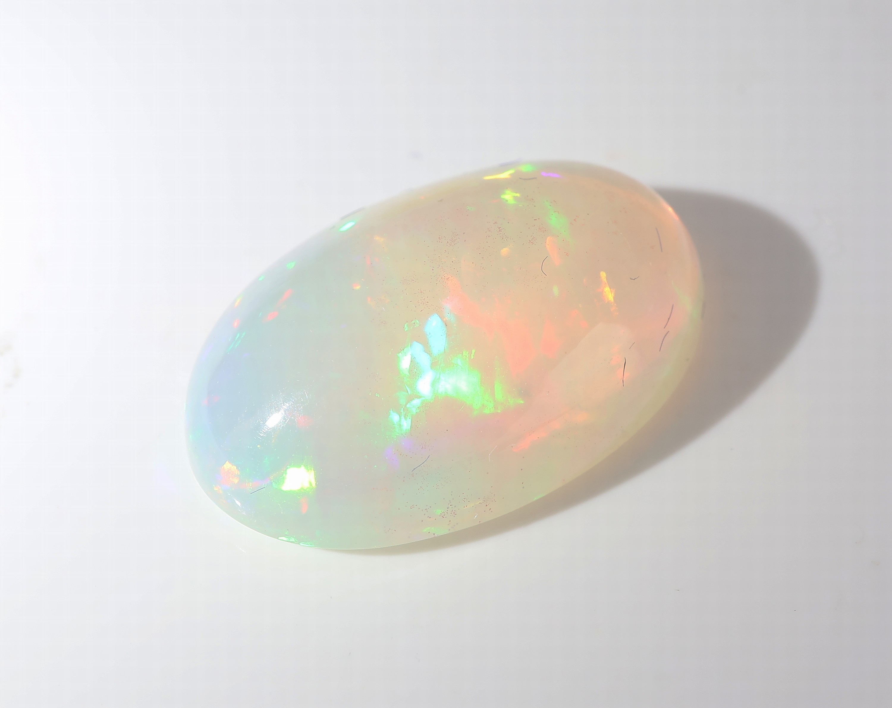 Detail c: Loser weißer Opal, ca. 7.74 ct, ovaler Cabochon, Farbspiel in Blau, Grün und Rot, ca.18.77 x 12.74 x 6.77 mm, Herkunft Äthiopien