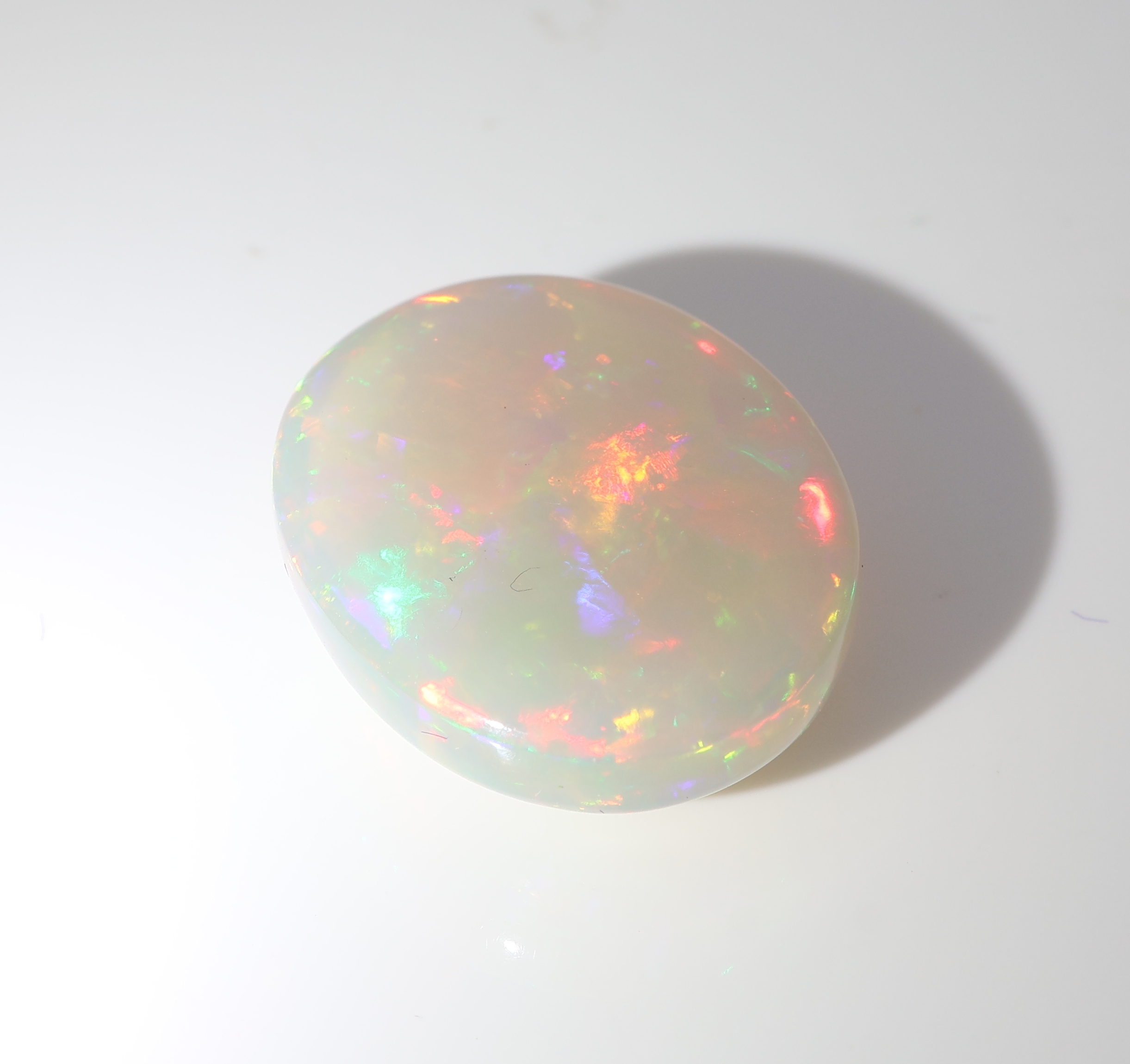 Detail b: Loser weißer Opal, ca. 7.47 ct, ovaler Cabochon, Farbspiel in Rot, Blau, Grün und Gelb, ca. 17.34 x 13.94 x 5.96 mm, Herkunft Äthiopien
