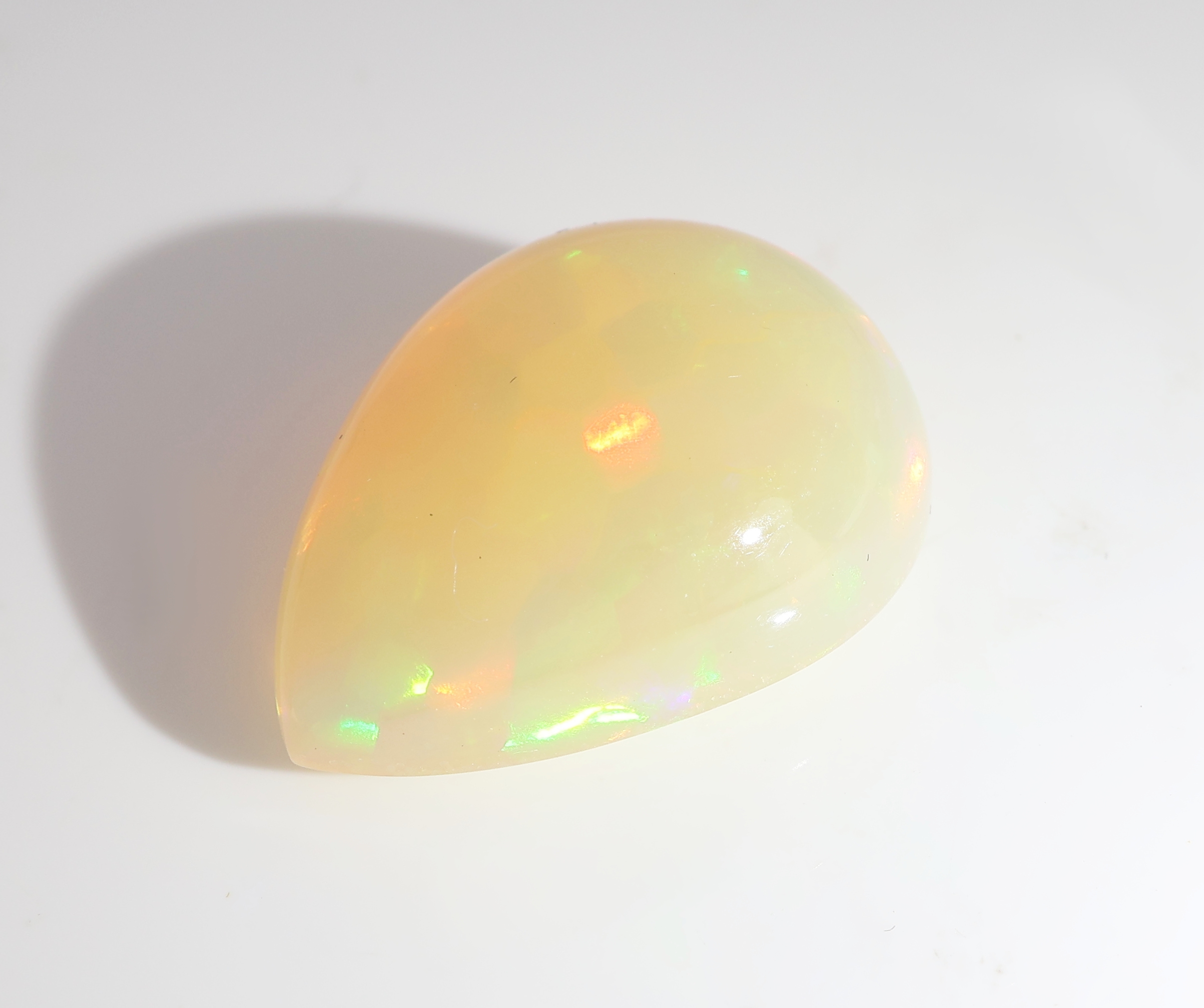 Detail b: Loser weißer Opal, ca. 5.25 ct, tropfenf. Cabochon, Farbspiel in Grün, Blau und Rot, ca.16.07 x 11.97 x 6.88 mm, Herkunft Äthiopien