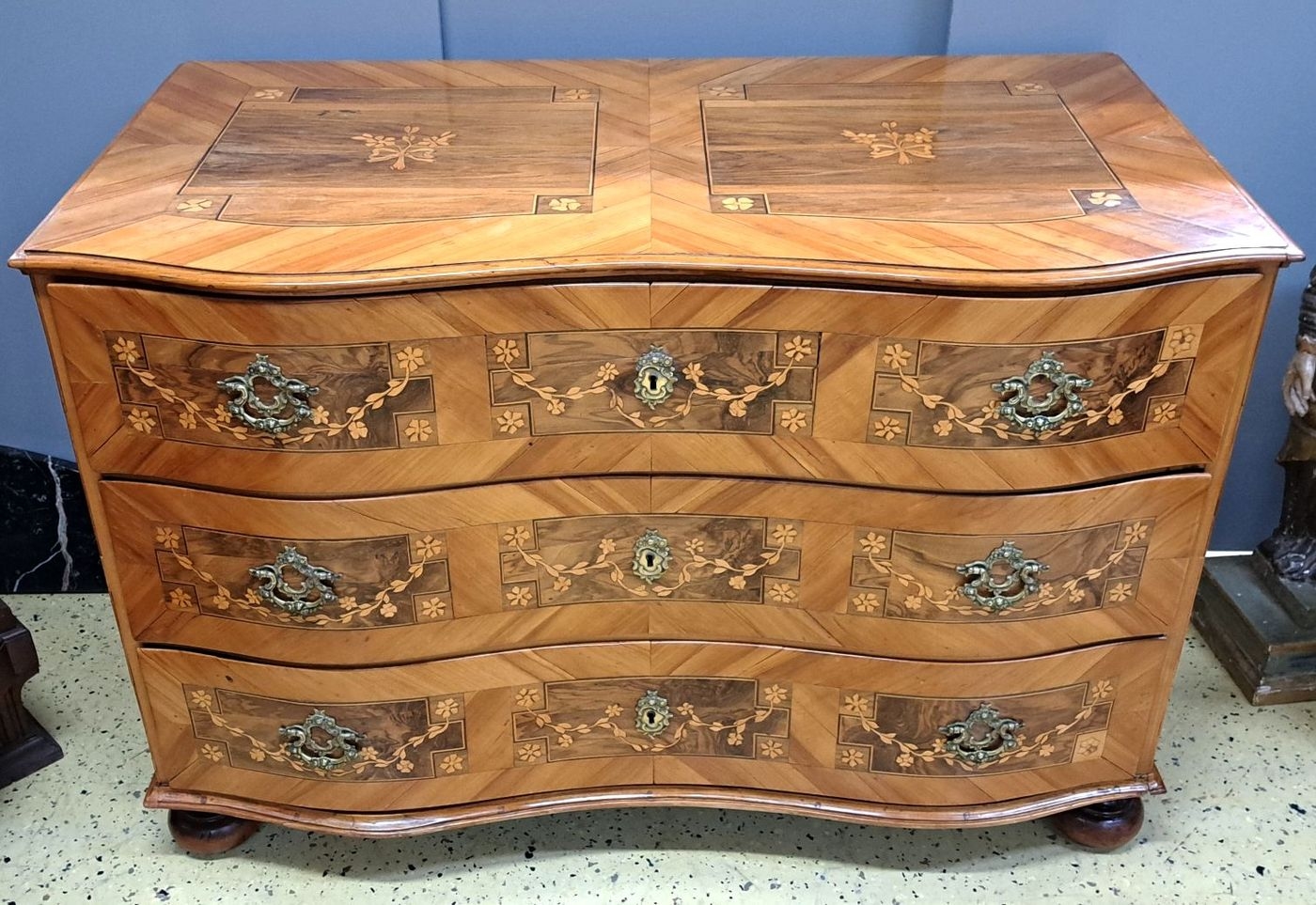 Detail a: Barock-Kommode, um 1750, Kirschbaumfurnier und z.T. Nußbaumfurnier, doppelt geschweift, Deckplatte,Front und Seiten mit aufwendiger Marketerie, ...