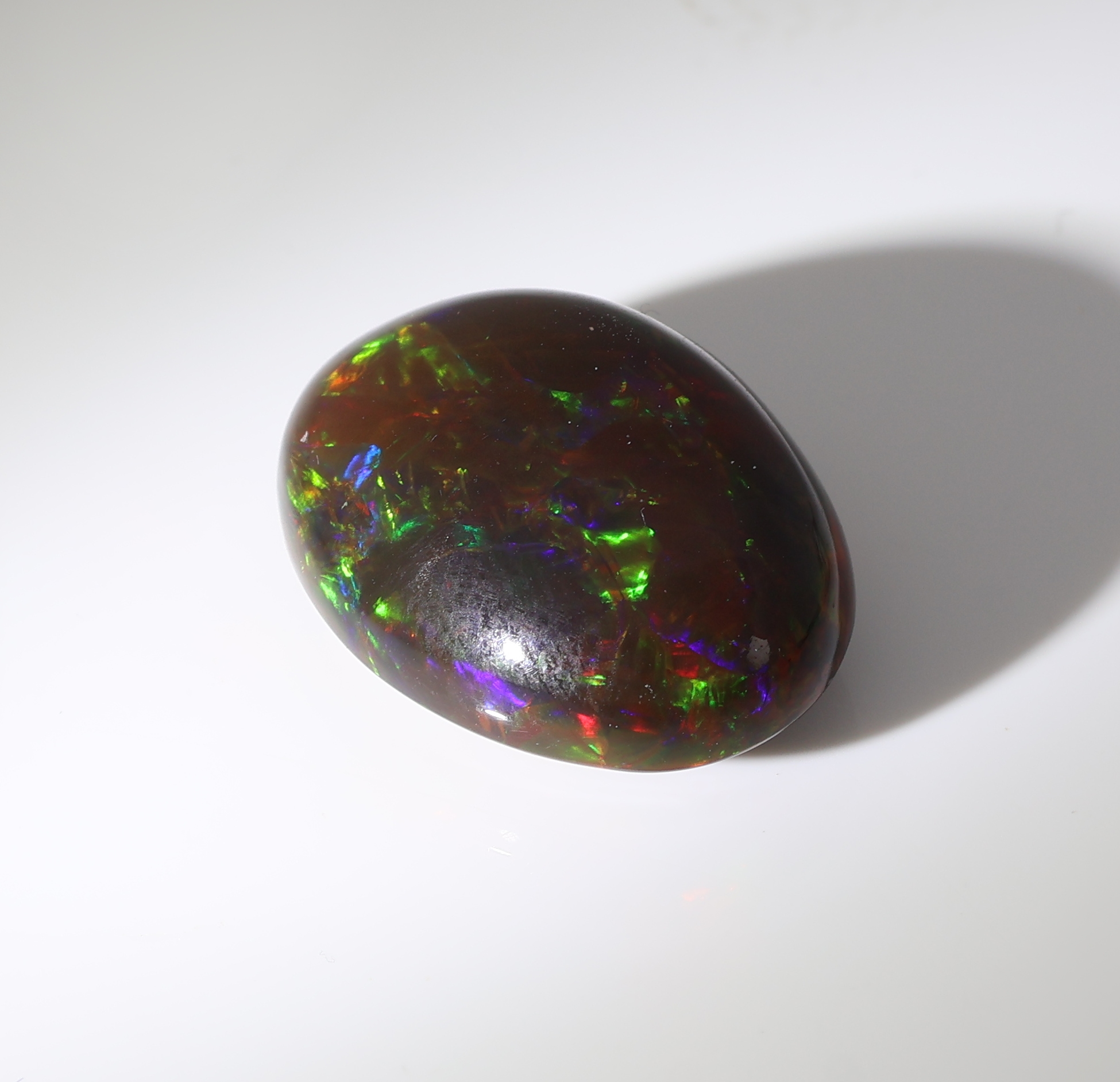 Detail d: Loser schwarzer Opal, ca. 10.91 ct, ovaler Cabochon, Farbspiel in Grün, Rot und Blau