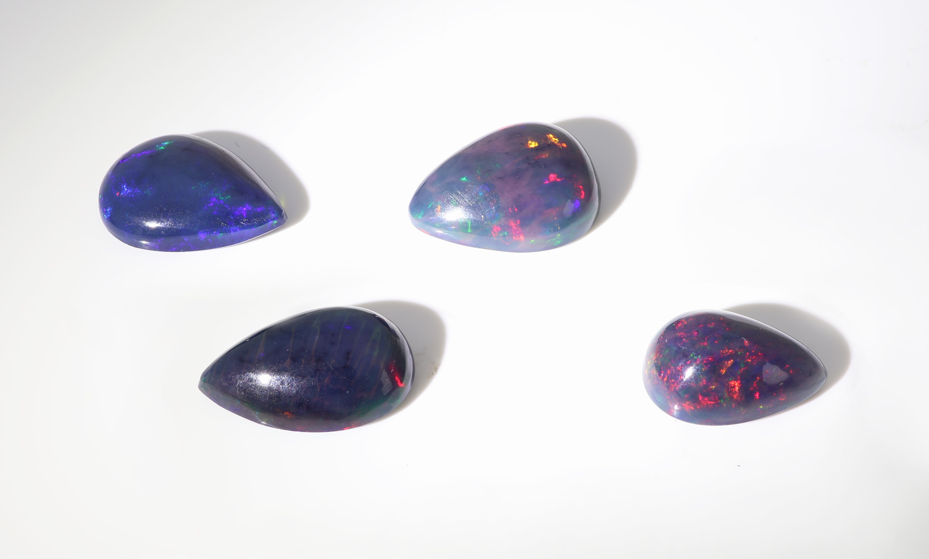 Detail b: lot 4 lose schwarze Opale, zus. ca. 12.05 ct, tropfenf. Cabochons in versch. Größen, Farbspiel in Blau, Grün und Rot