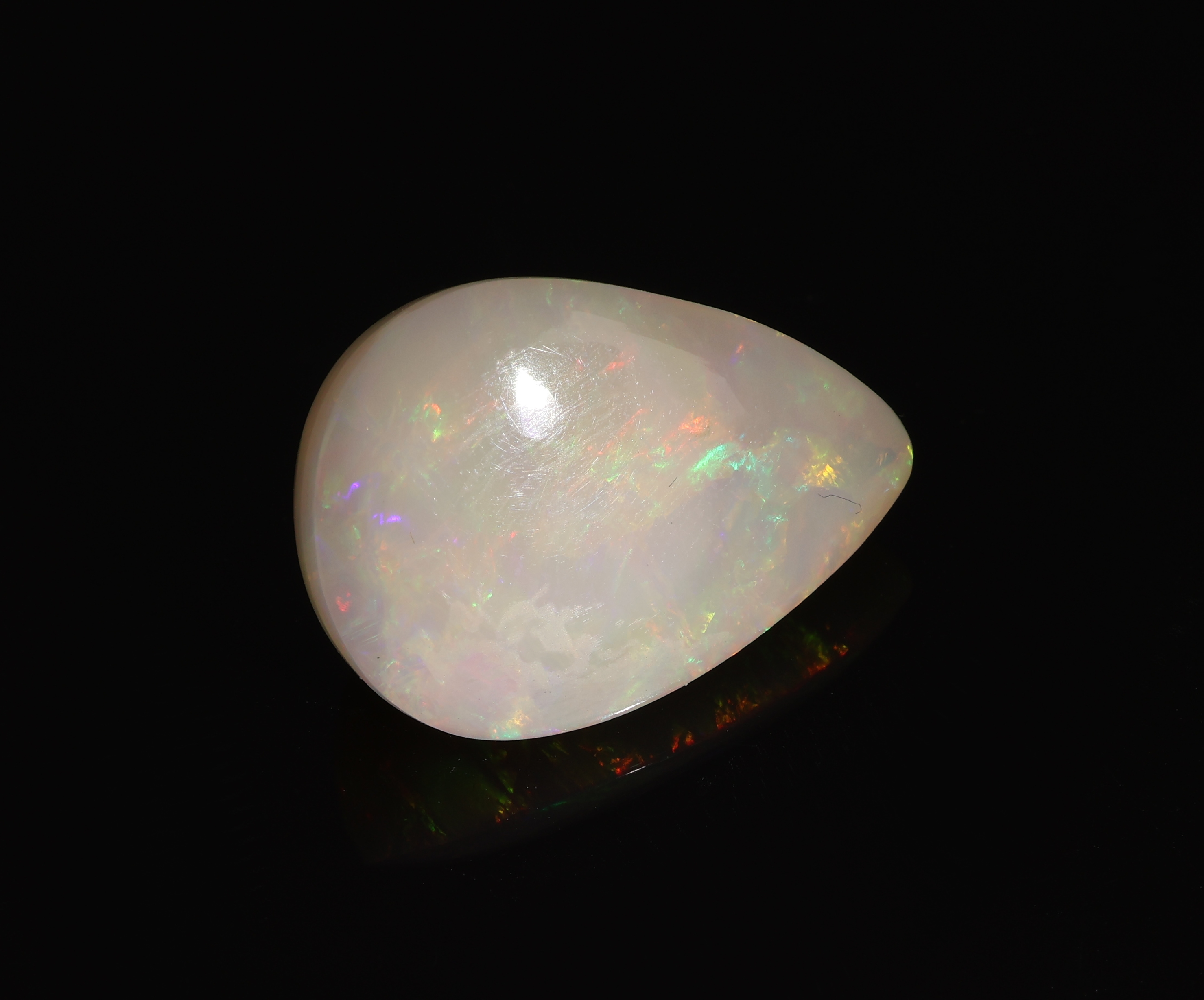 Detail c: Loser Opal, ca. 16.43 ct, tropfenf. Cabochon, zartes Farbspiel in Grün, Rot und Blau