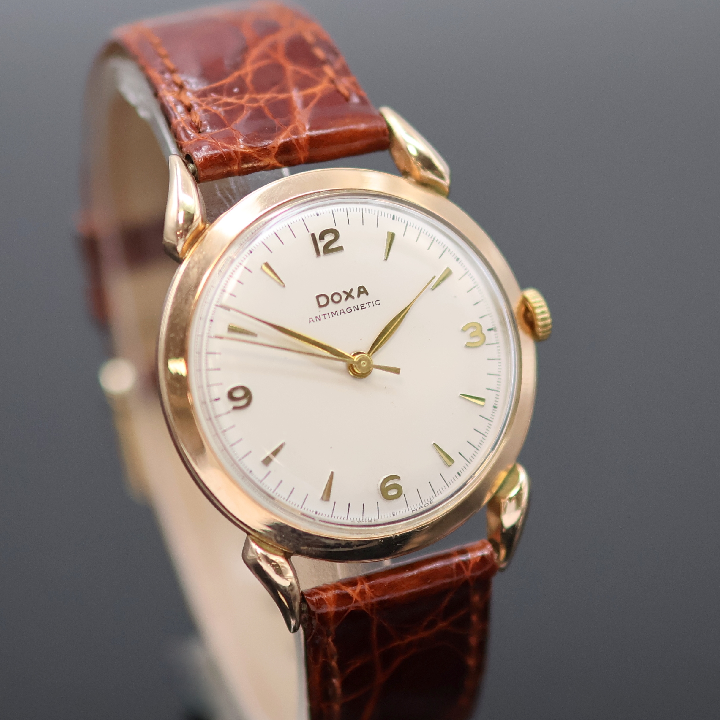 Detail b: DOXA Armbanduhr in RG 585/000, Schweiz um 1960, Handaufzug, tropfenförm. Anstöße, Boden aufgedr., silb. Zifferbl. m. gold. Std.-Ind. u. Zahlen, ...
