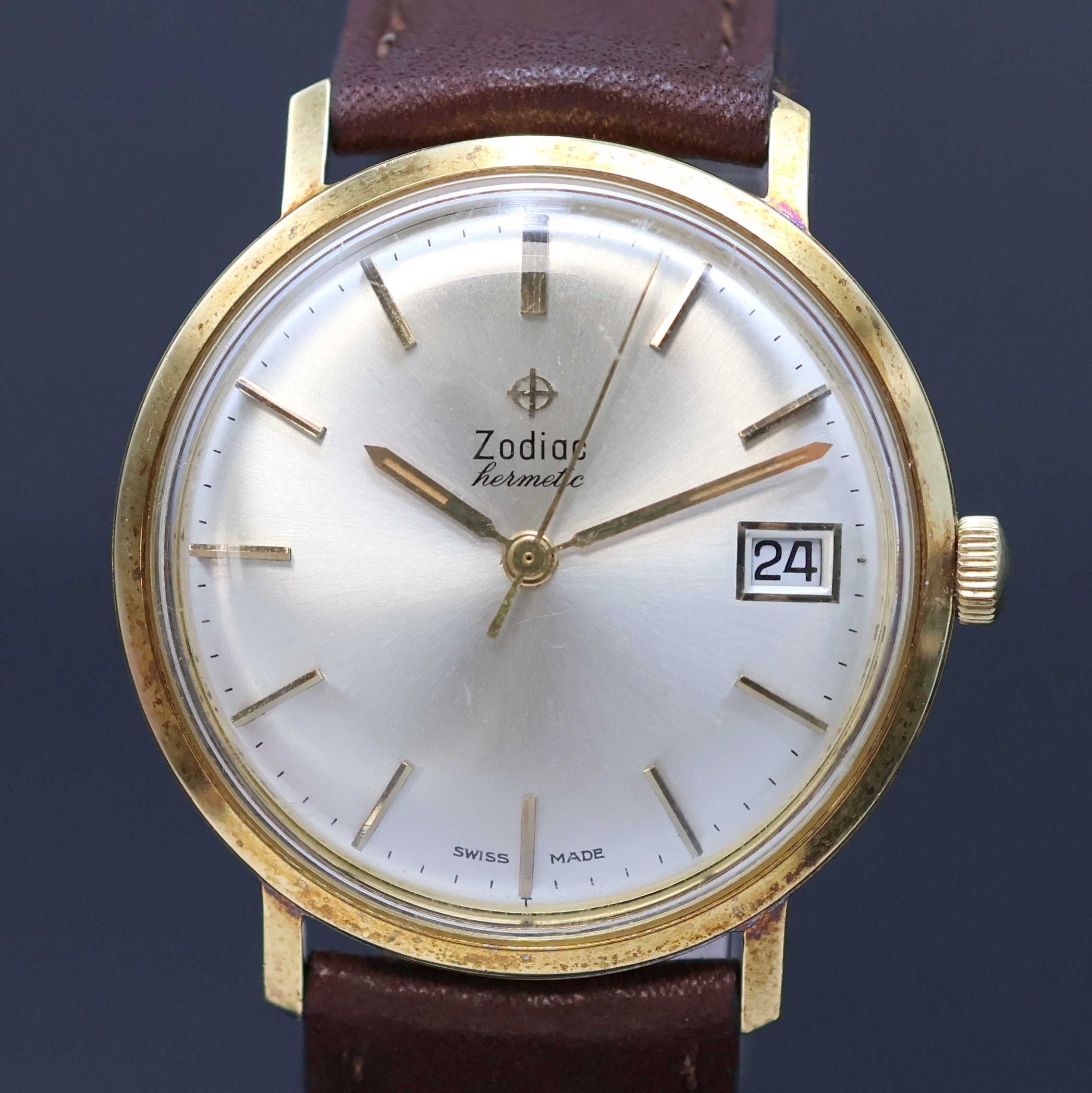 Detail b: ZODIAC Hermetic vergoldete Armbanduhr, Schweiz um 1960, Handaufzug, neutr. Lederband m. Zodiac Dornschl., Boden verschr., silb. Zifferbl. m. gold. ...
