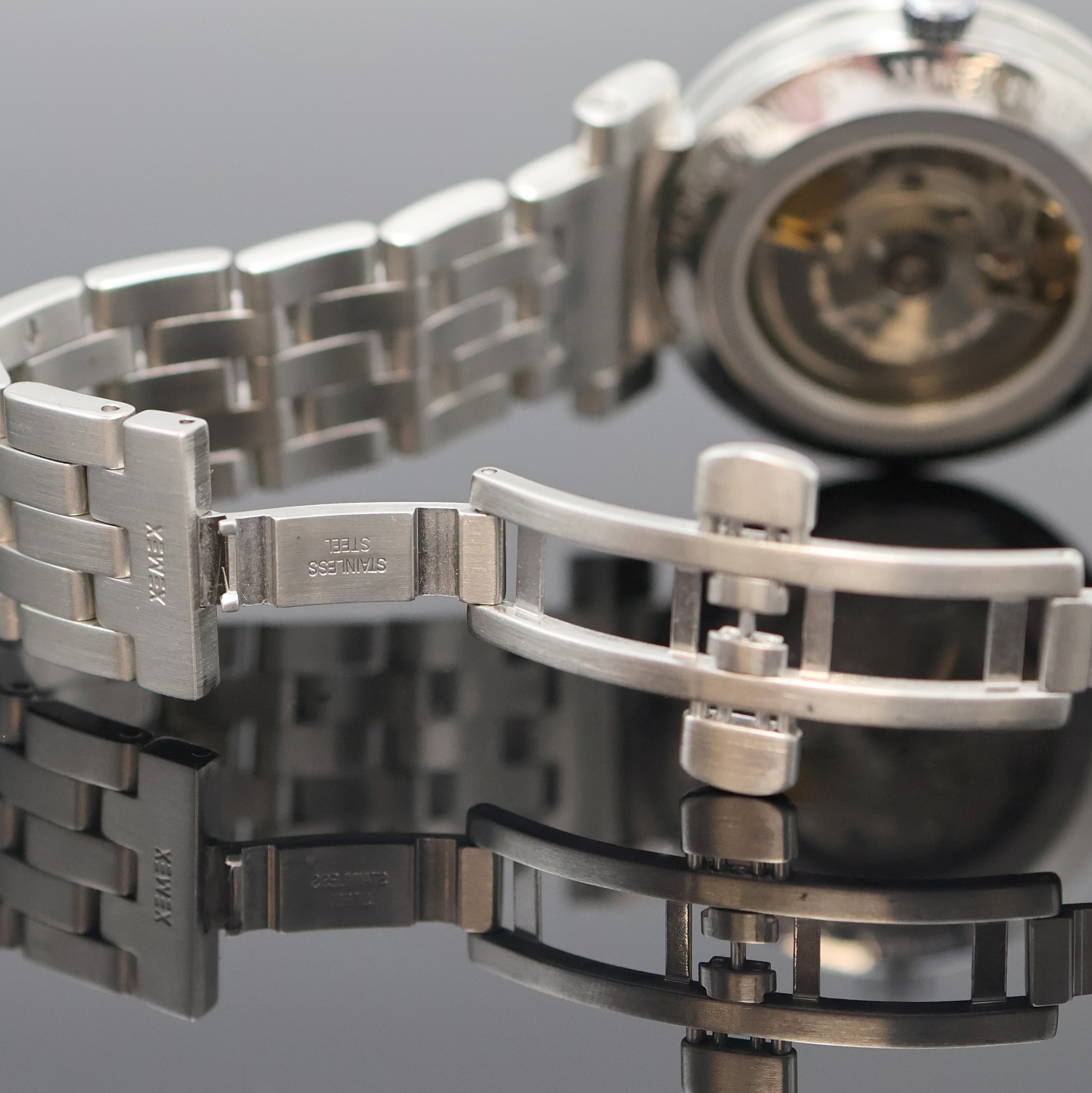 Detail e: XEMEX Herrenarmbanduhr in Stahl Design Külling, Schweiz um 2000, Automatik, beids. vergl. Geh. inkl. orig. Gliederband m. dopp. Faltschl., Boden ...
