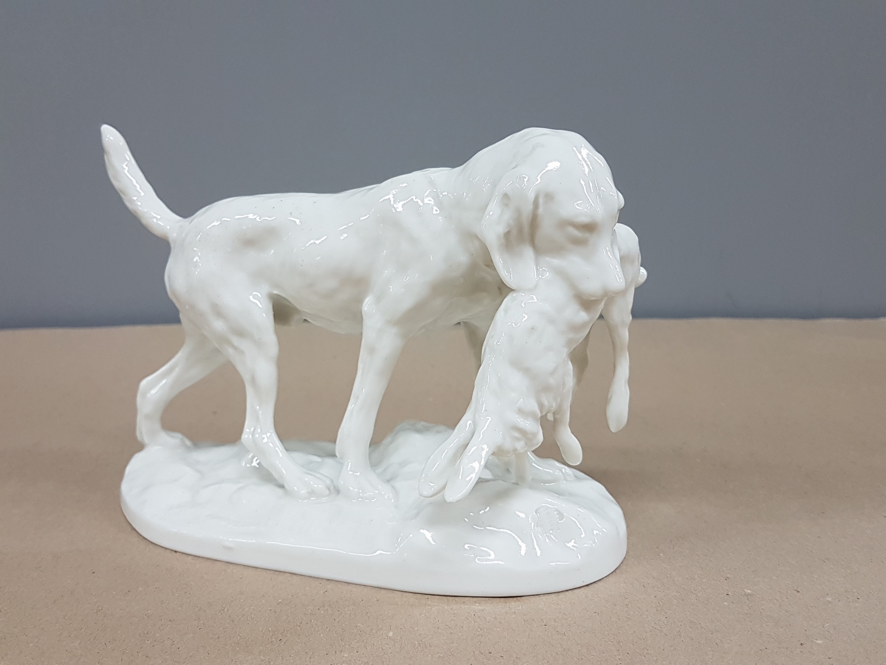 Detail g: 2 Porzellanfiguren, Nymphenburg, 20.Jh., Weißporzellan, liegende Dogge, L. 24 cm; Jagdhund mit erlegtem Kaninchen, L. 15.5 cm, jeweils ...