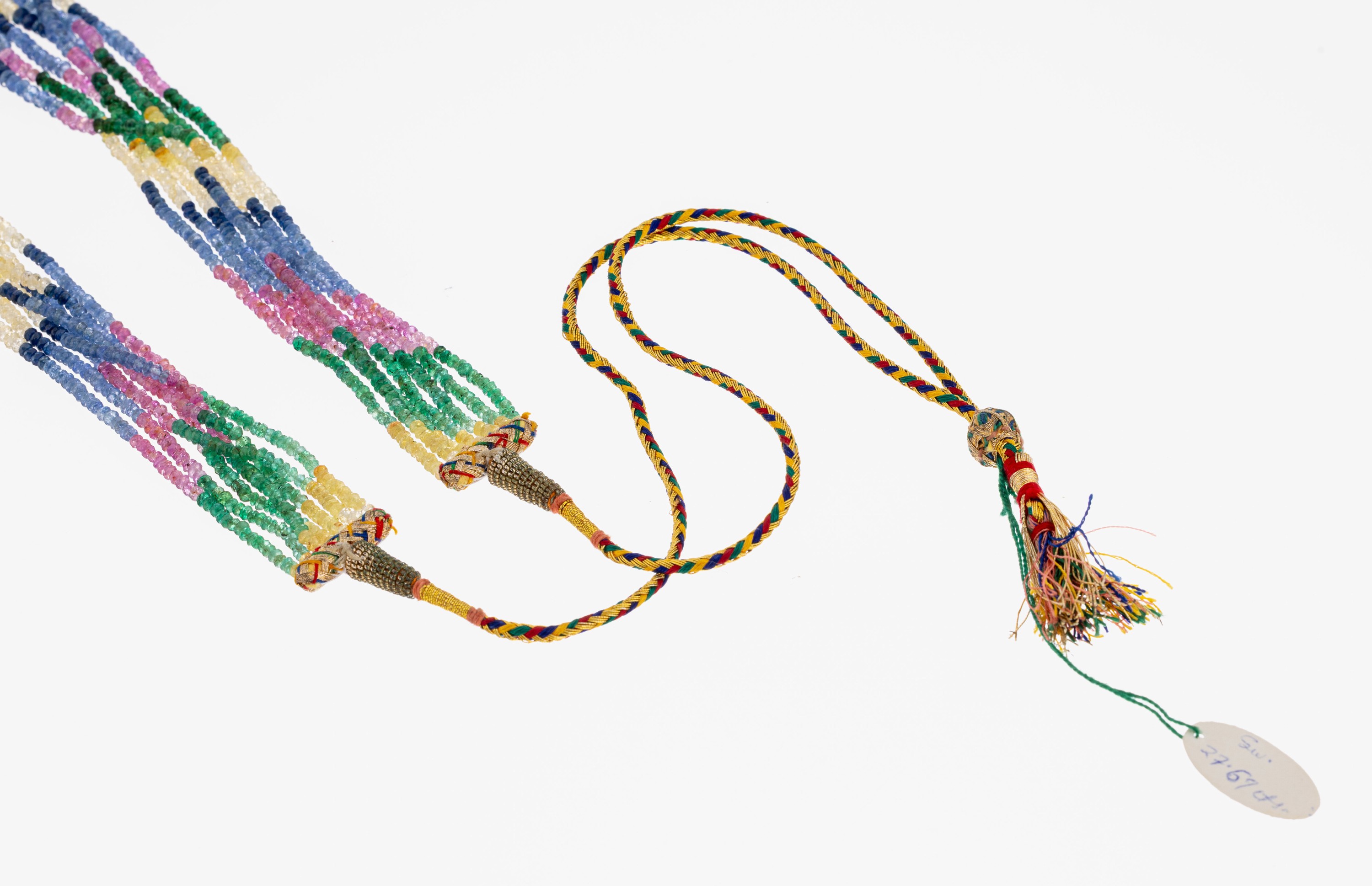 Detail a: Farbstein-Collier, wohl Indien, 7-rhg., facett. Rubine, Smaragde und Saphire in versch. Farben, verlaufend, L. variabel durch Seidenkordel 45-94 cm