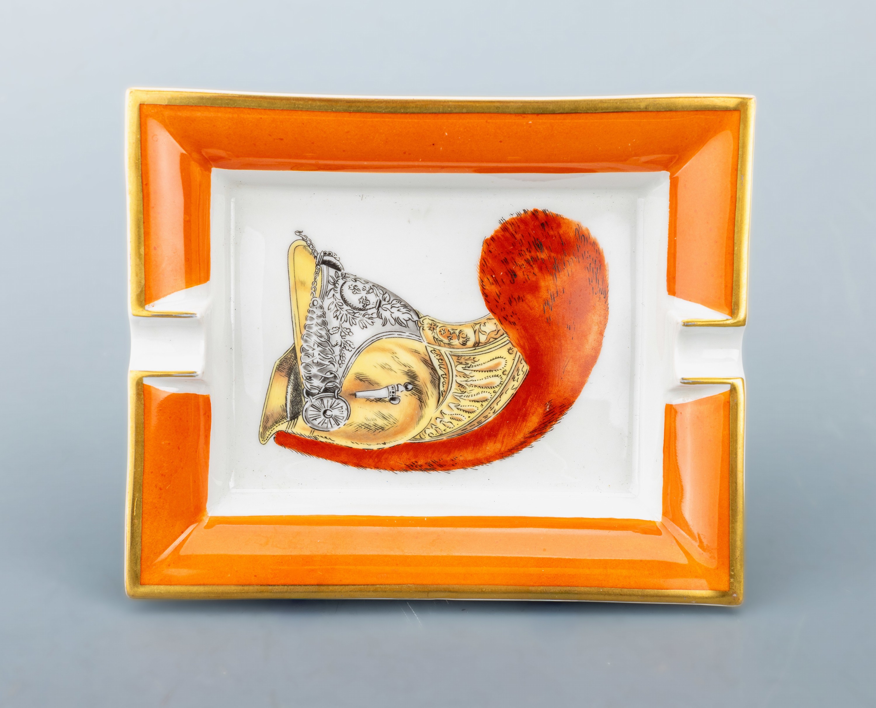Detail a: HERMES Aschenbecher, Porzellan mit polychromen Dekor, Darstellung eines franz. Kürassierhelm, Fahne Orange mit goldf. Umrandung, Boden mit orangef. ...