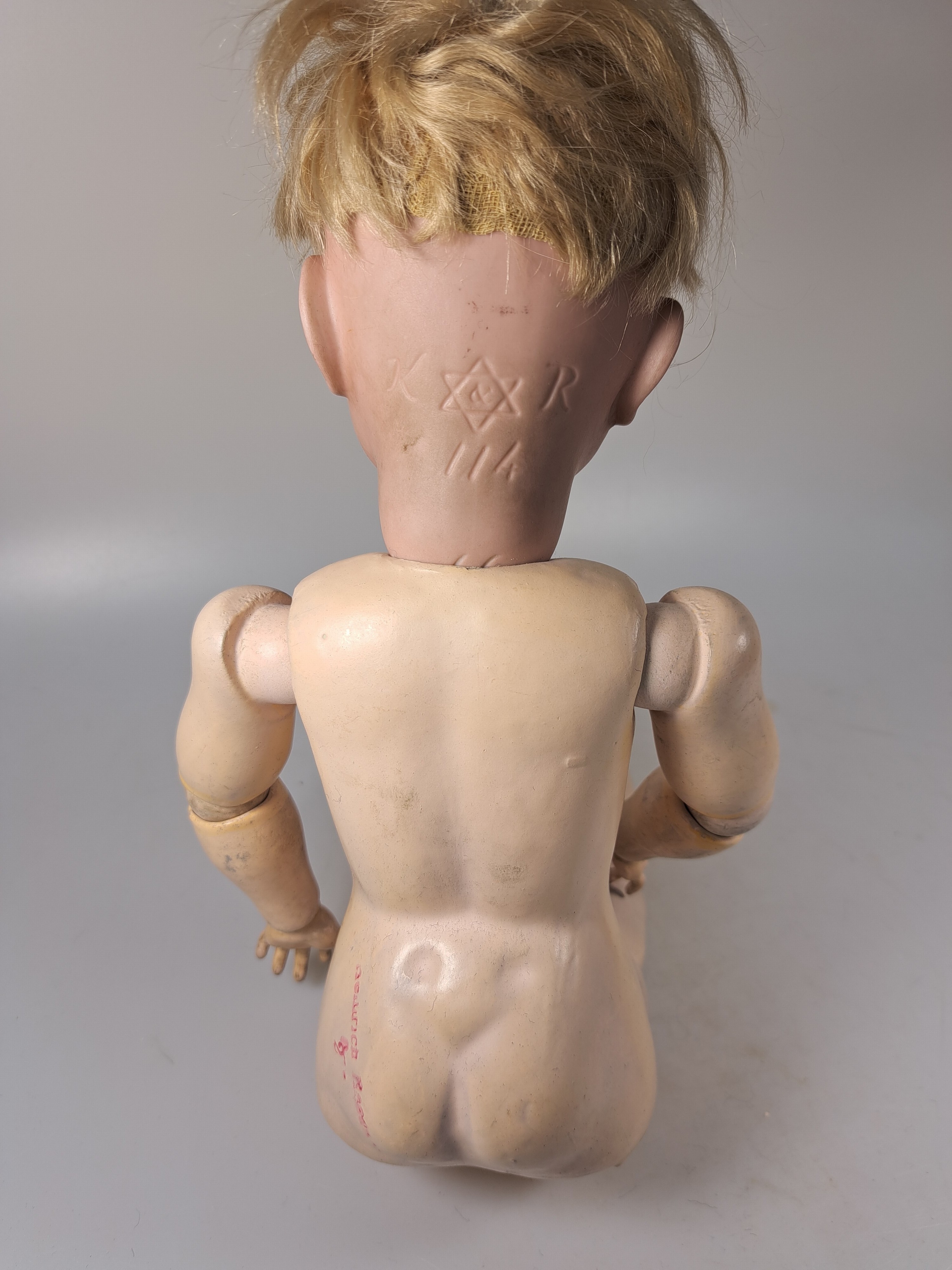 Detail g: Porzellankopfpuppe, Kämmer & Reinhard, 114, um 1909, braune Schlafaugen, geschlossener Mund, blonde Mohairperücke, Gliederkörper, l. Gebr.-spuren, ...