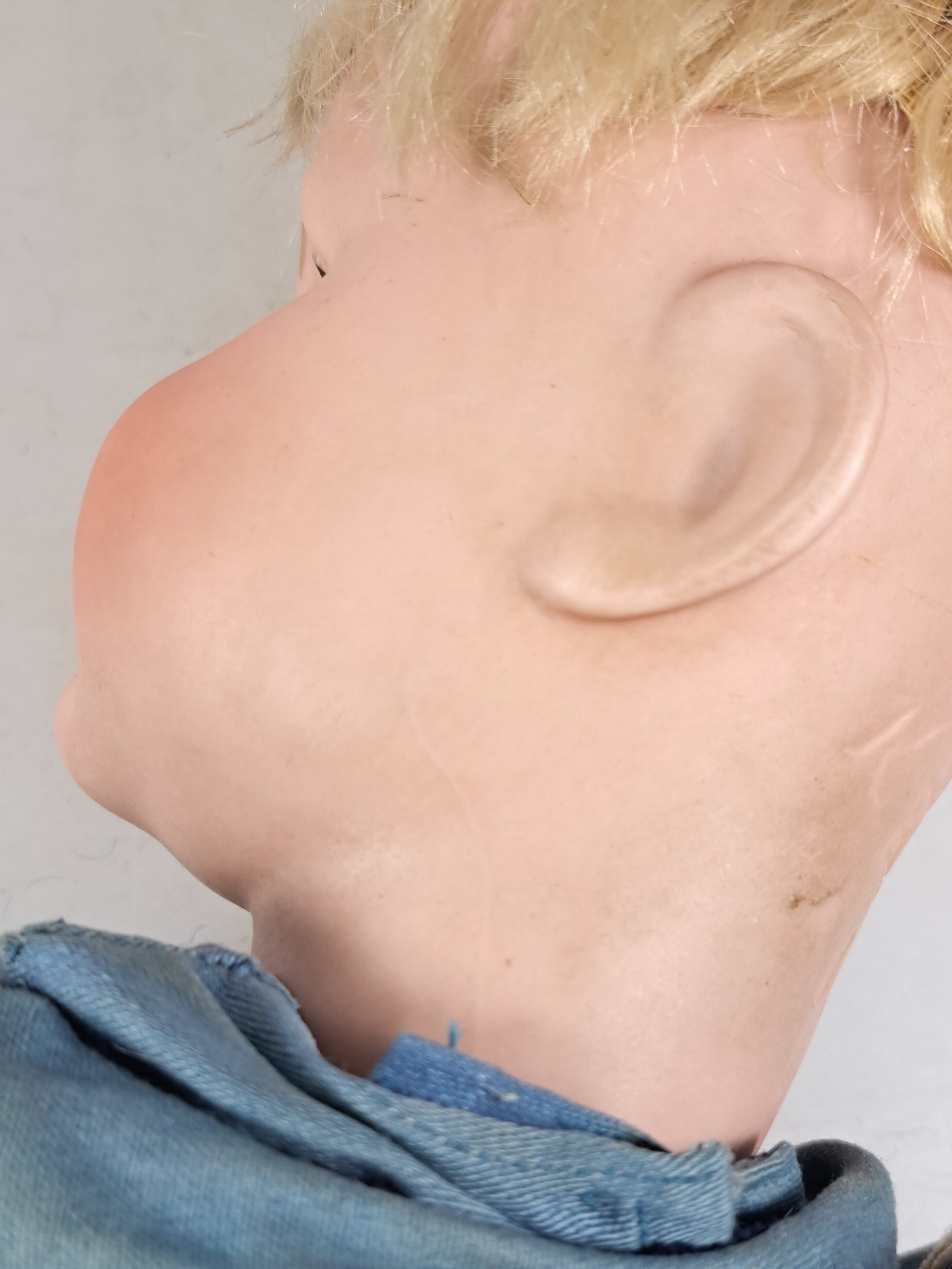 Detail i: Porzellankopfpuppe, Kämmer & Reinhard, 114, um 1909, braune Schlafaugen, geschlossener Mund, blonde Mohairperücke, Gliederkörper, l. Gebr.-spuren, ...