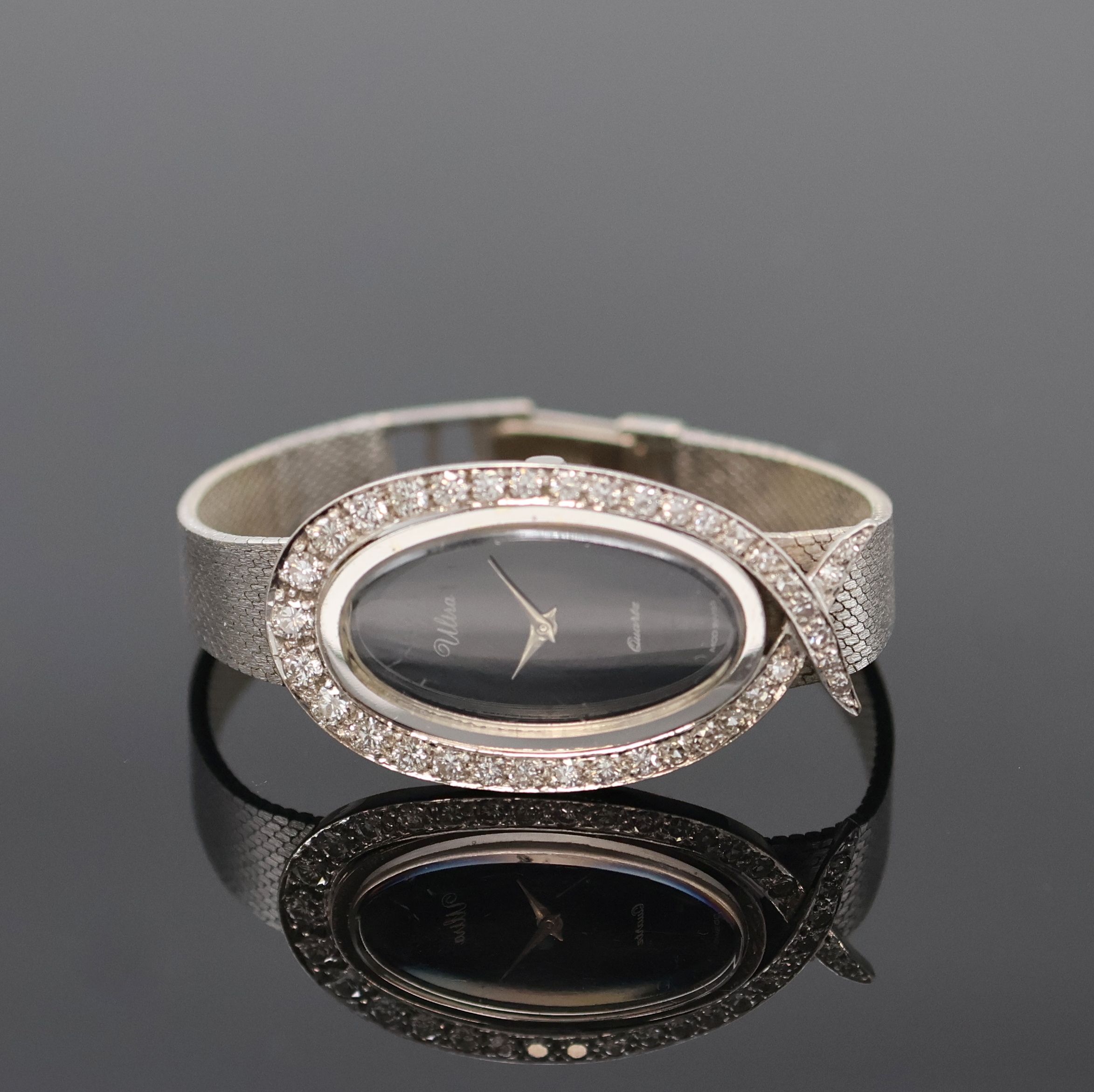 ULTRA Damenarmbanduhr in WG 585/000 mit Diamantbesatz, um 1960, Boden aufgedr., Milanaiseband, Lünette aufw. m. Diamanten bes., schwarzes Zifferbl., ...