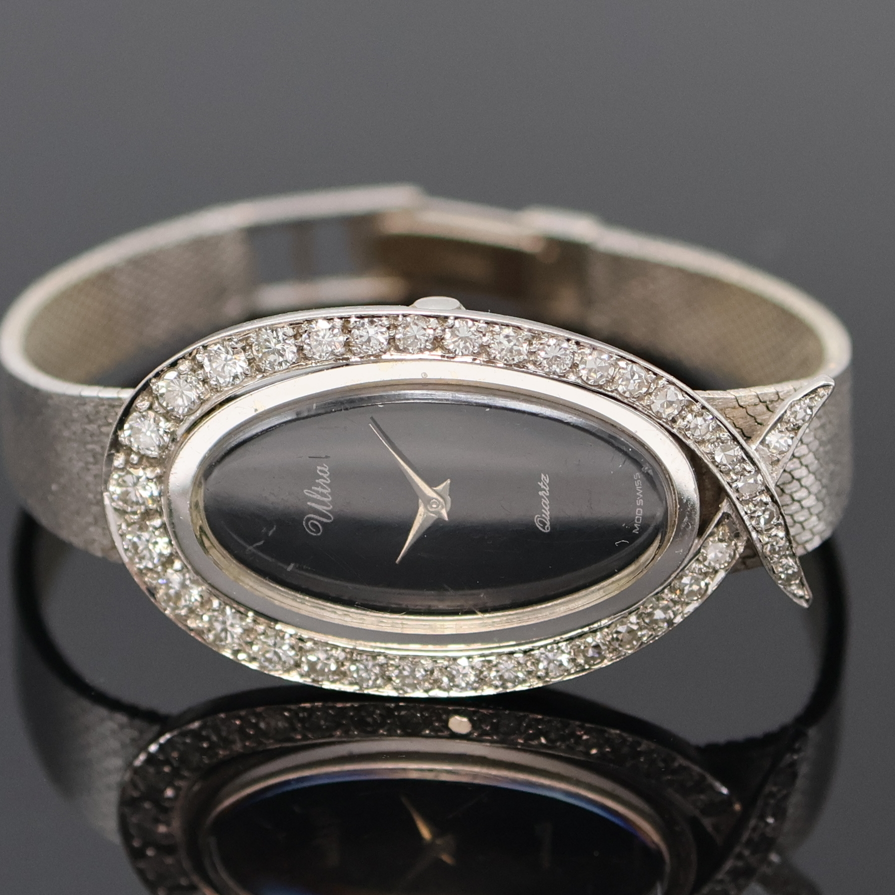 Detail a: ULTRA Damenarmbanduhr in WG 585/000 mit Diamantbesatz, um 1960, Boden aufgedr., Milanaiseband, Lünette aufw. m. Diamanten bes., schwarzes Zifferbl., ...