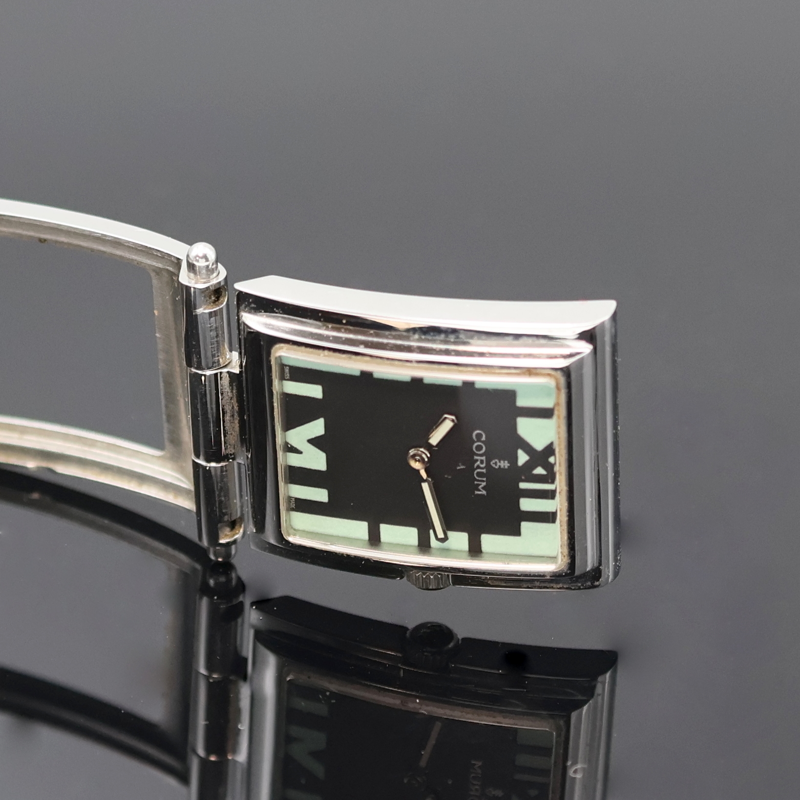Detail e: CORUM Armbanduhr Serie Tabogan Referenz 64.151.20, Schweiz um 2000, quarz, Edelstahlgeh. inkl. neutr. Flexband, Oberteil zur Zeigerst. aufklappbar, ...