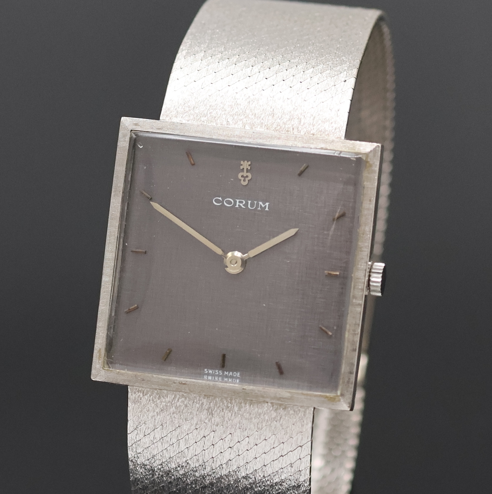 Detail a: CORUM Armbanduhr in WG 750/000, Schweiz um 1960, Handaufzug, orig. Goldband, Boden aufgedr., graues Zifferbl. m. aufges. Std.- Ind., silb. Zeiger, ...