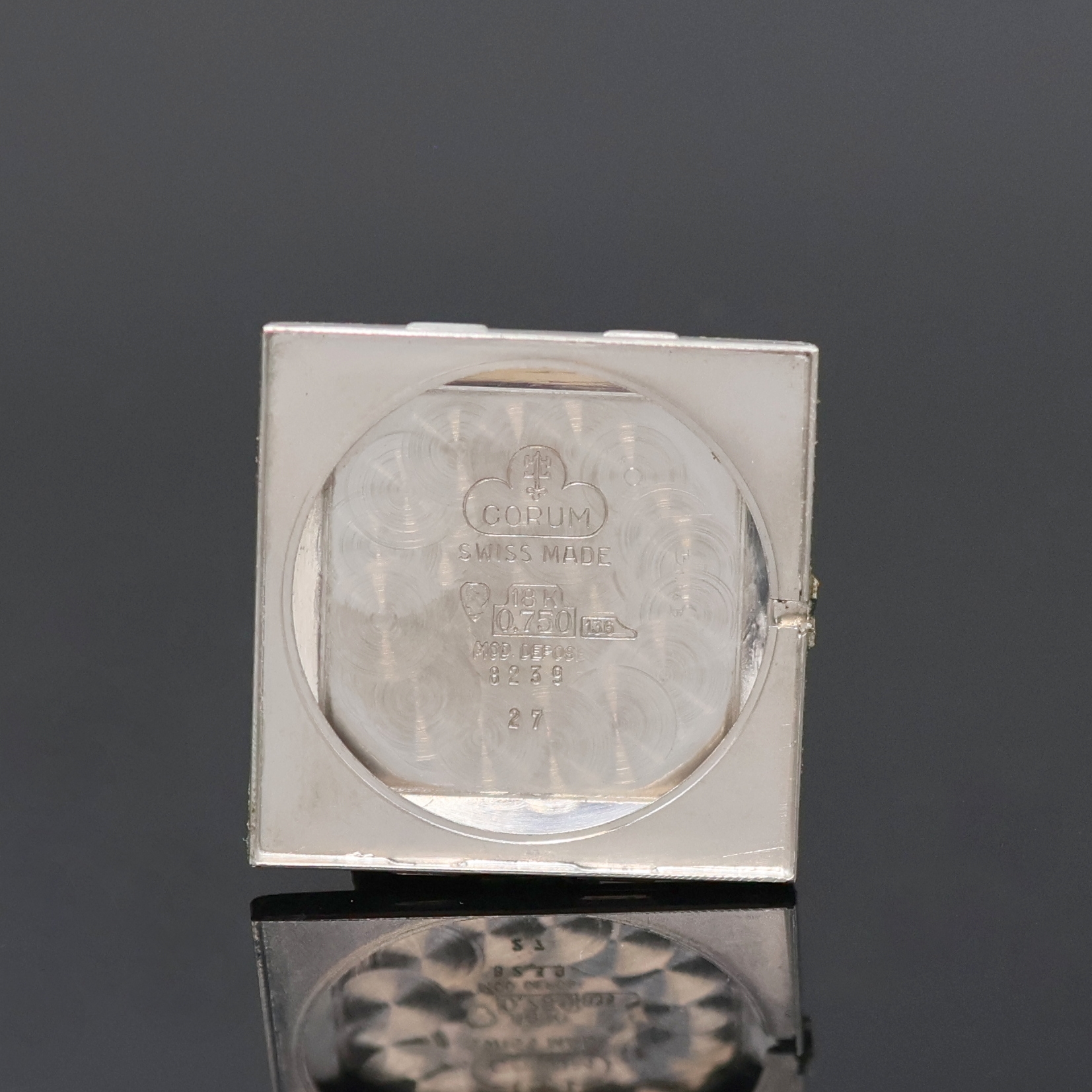 Detail e: CORUM Armbanduhr in WG 750/000, Schweiz um 1960, Handaufzug, orig. Goldband, Boden aufgedr., graues Zifferbl. m. aufges. Std.- Ind., silb. Zeiger, ...