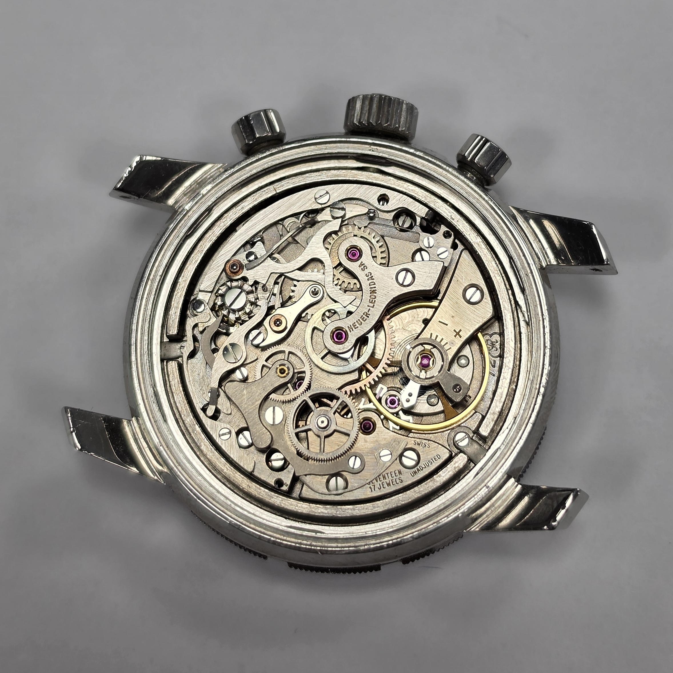 Detail e: HEUER Autavia Schaltradchronograph Referenz 2446C, Handaufzug, Schweiz um 1970, Boden aufgedr., schwarze Kontrastzifferbl. mit silb. Hilfszifferbl., ...