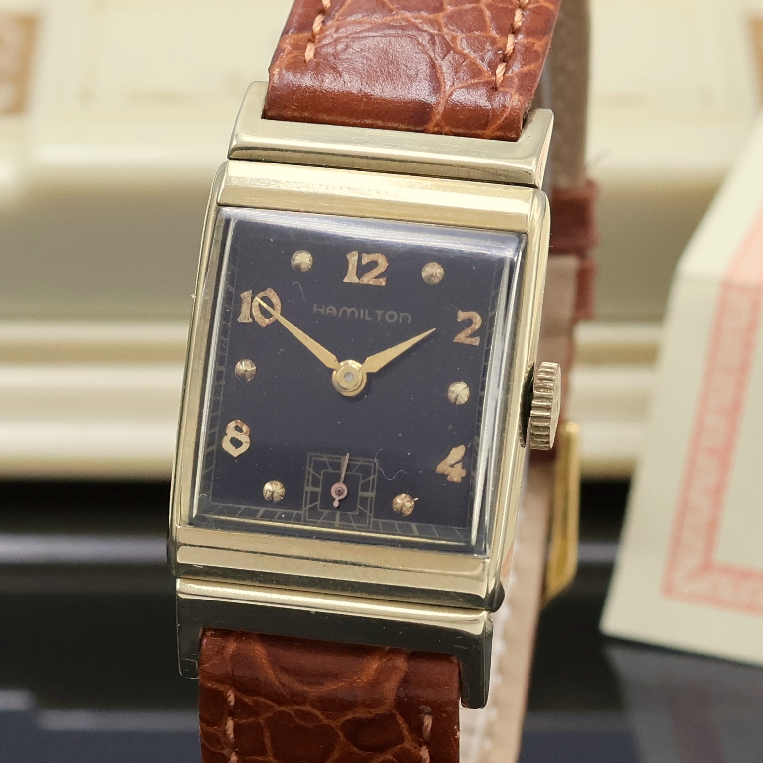 Detail a: HAMILTON Armbanduhr in GG 585/000, USA um 1950, 2-teil., rechteckiges Geh., Boden m. Widmungsgravur aufgedr., schwarzes Zifferbl. rest., gold. ...
