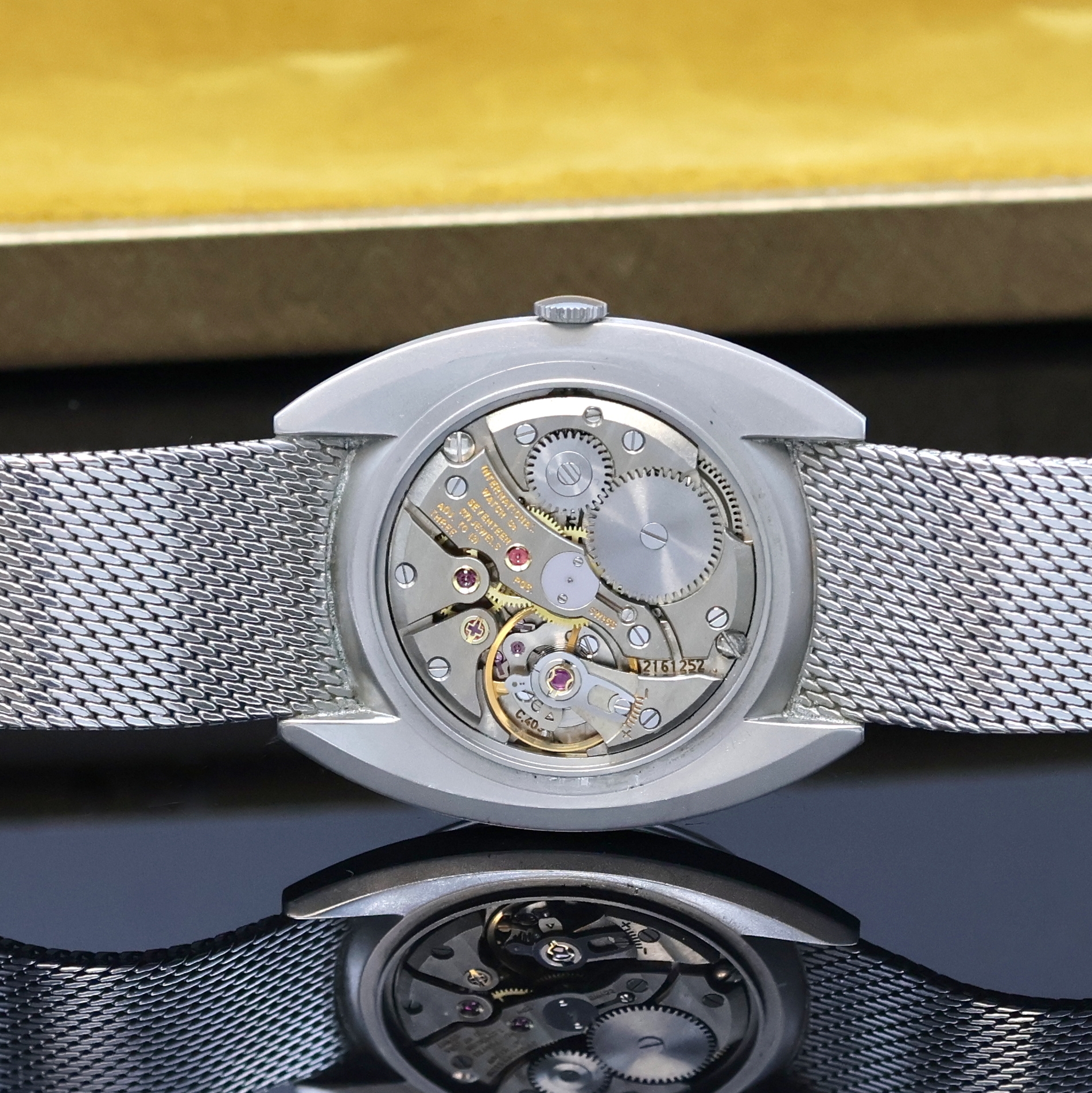 Detail e: IWC Herrenarmbanduhr in Stahl am angesetzten original Milanaiseband, Schweiz um 1970, 3- teil. Geh., Boden und Glasrand aufgedr., weißes Zifferbl. ...
