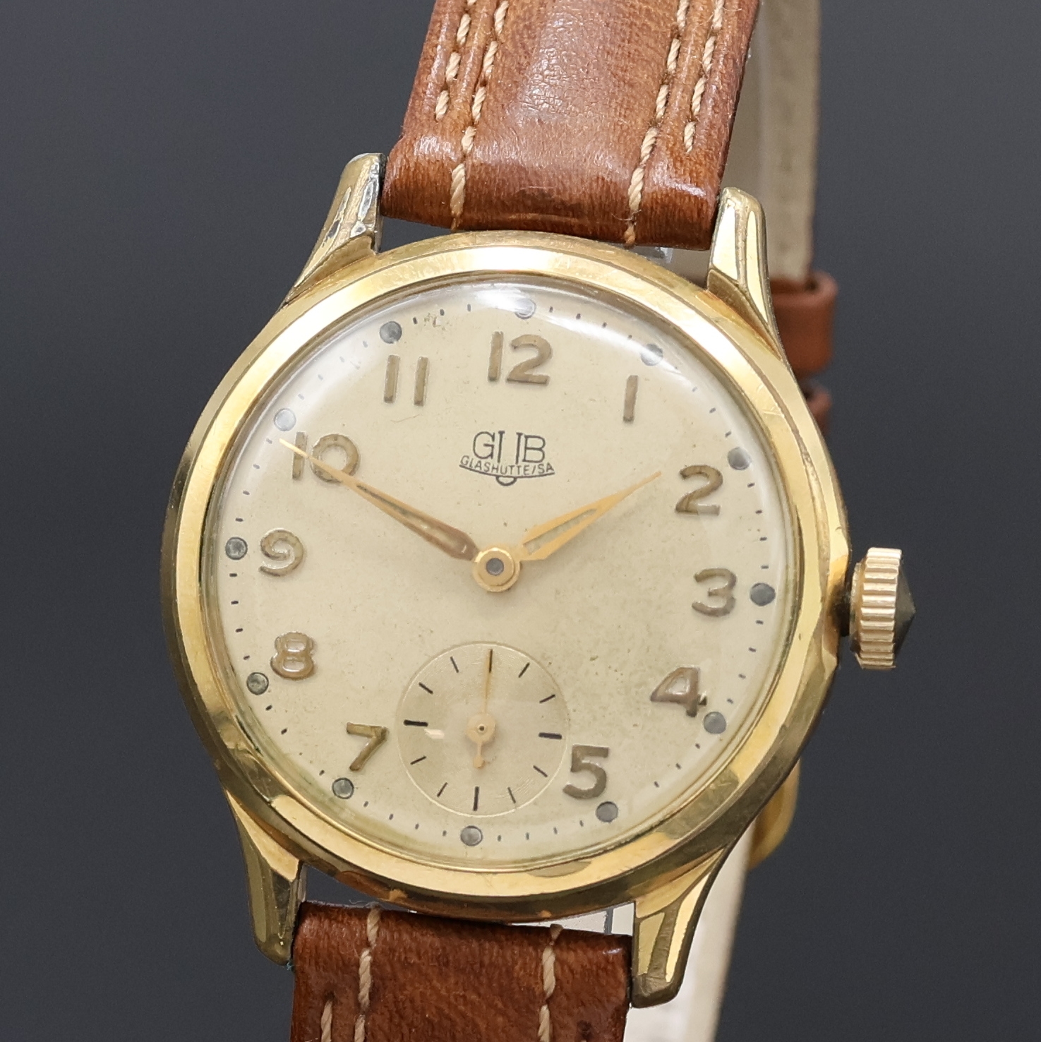 Detail a: GUB vergoldete Herrenarmbanduhr Kaliber 60, DDR um 1955, Handaufzug, 2-teil. Geh., Stahlboden verschr., silb. Zifferbl. pat., gold. arab. Zahlen, ...