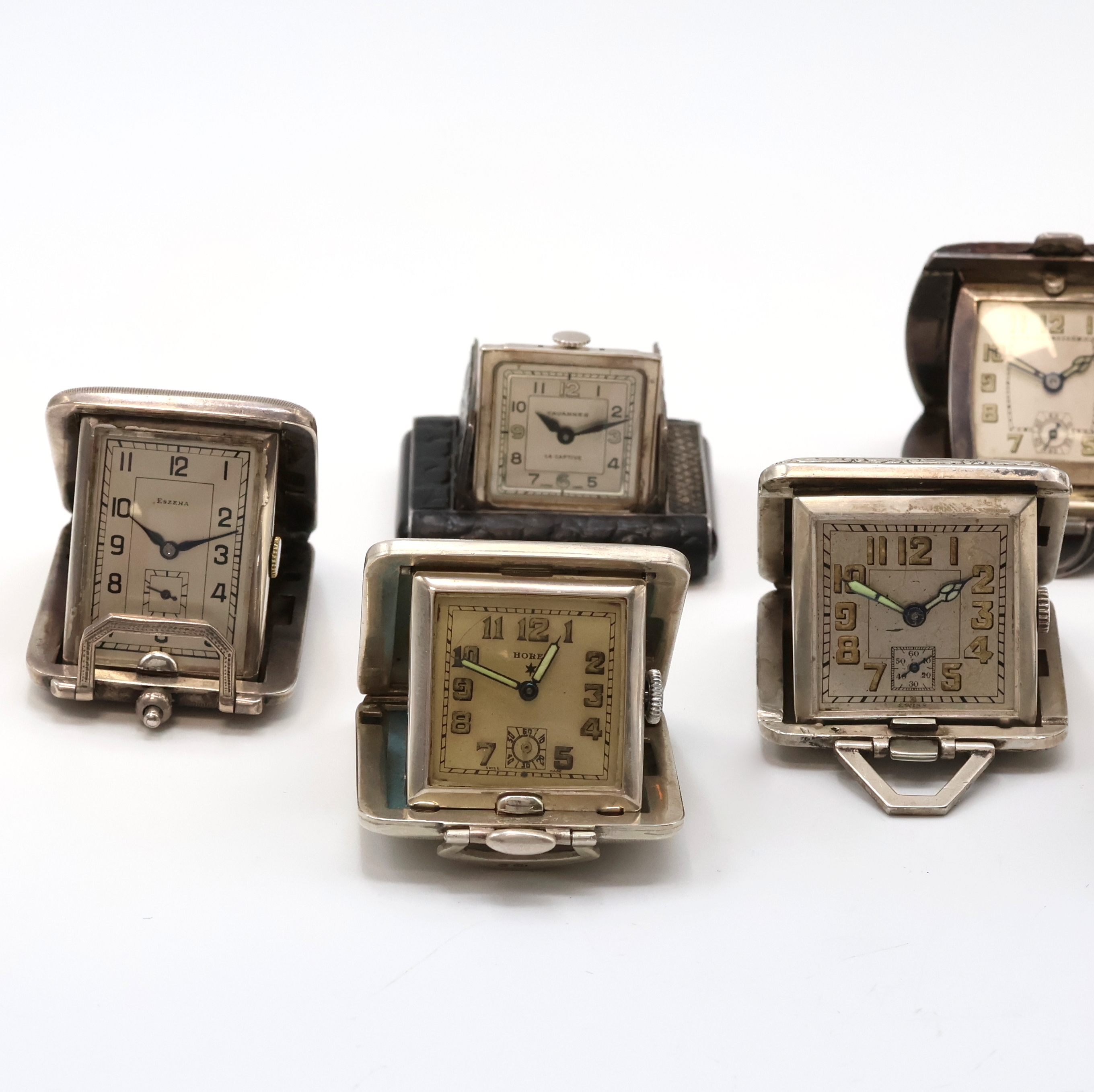 Detail a: 7 Reiseührchen in Silber, Schweiz um 1930, Handaufzug, silb. Zifferbl., teilw. m. Leuchtzahlen, aufstellbare Gehäuse, teils. Leder-bezogen, teils ...