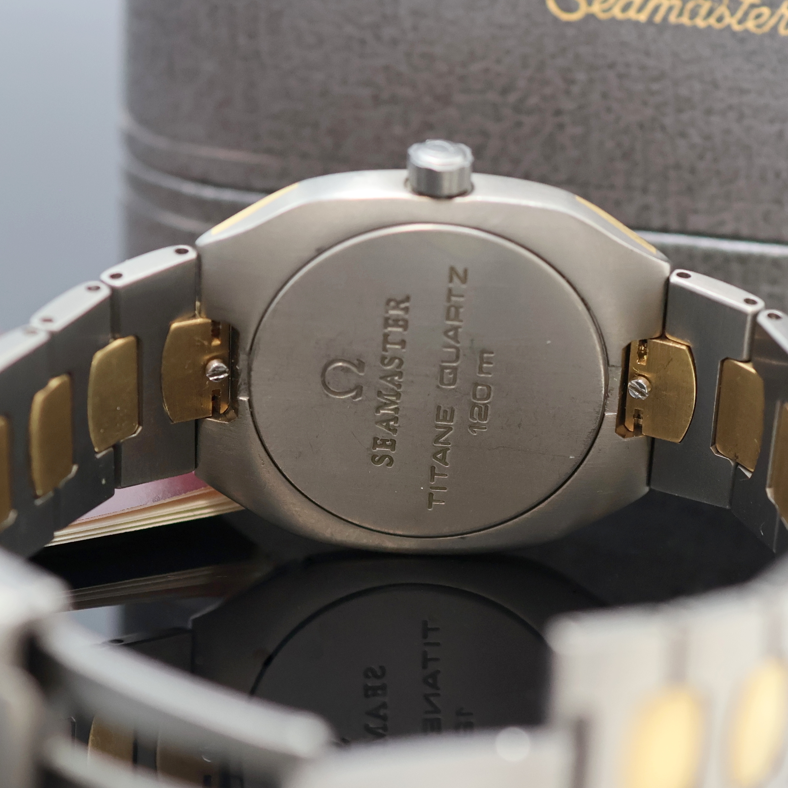 Detail f: OMEGA Seamaster Polaris Armbanduhr in Titan Referenz 196.0291/396.0981, Schweiz um 1990, quarz, Geh. Gold-intarsiert, orig. Gliederband m. dopp. ...