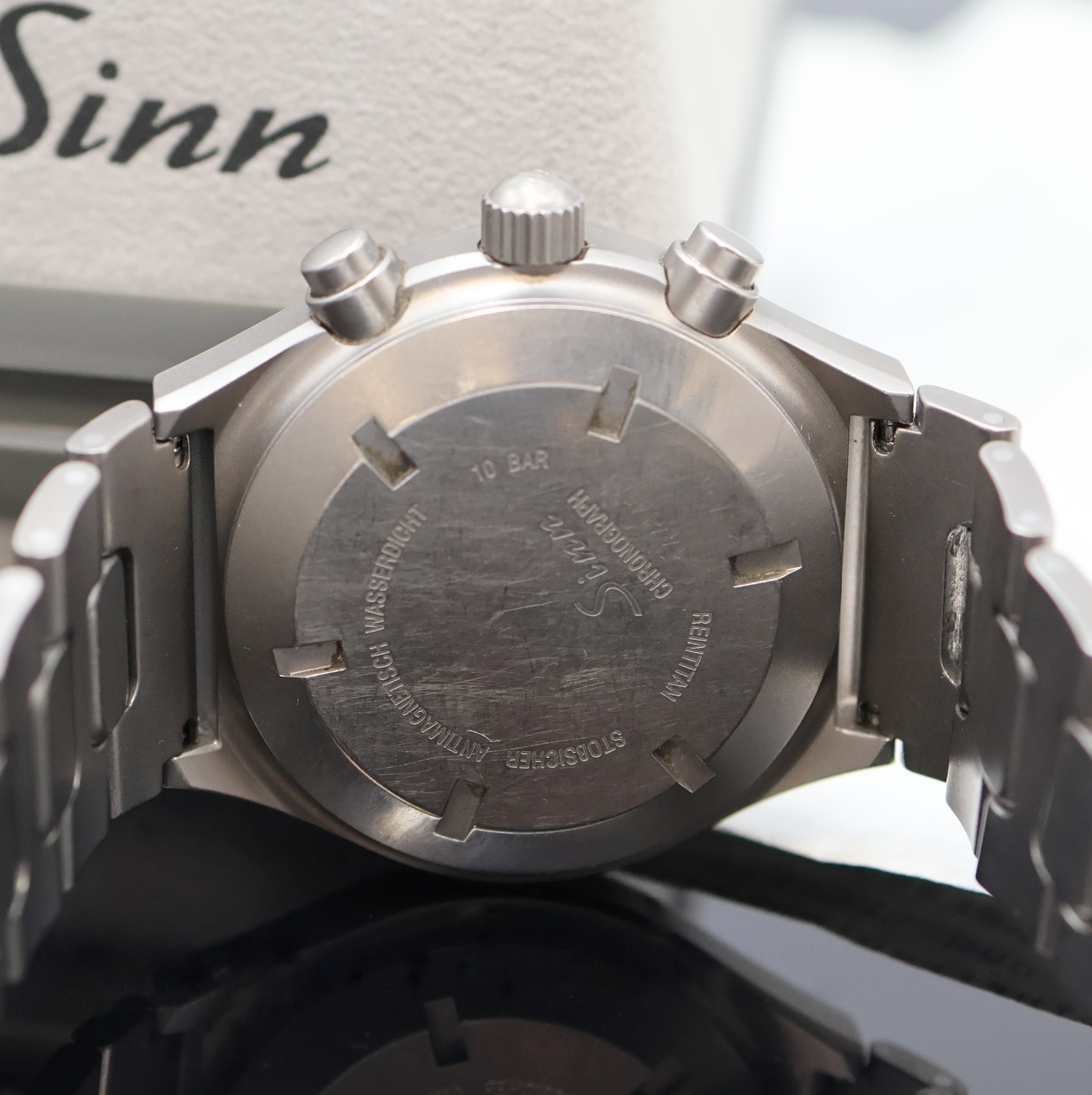 Detail e: SINN Armbandchronograph Referenz 144, Deutschland um 1995, Automatik, Titangeh. inkl. orig. Titan-Gliederband m. Faltschl., Tauchverlängerung, Boden ...