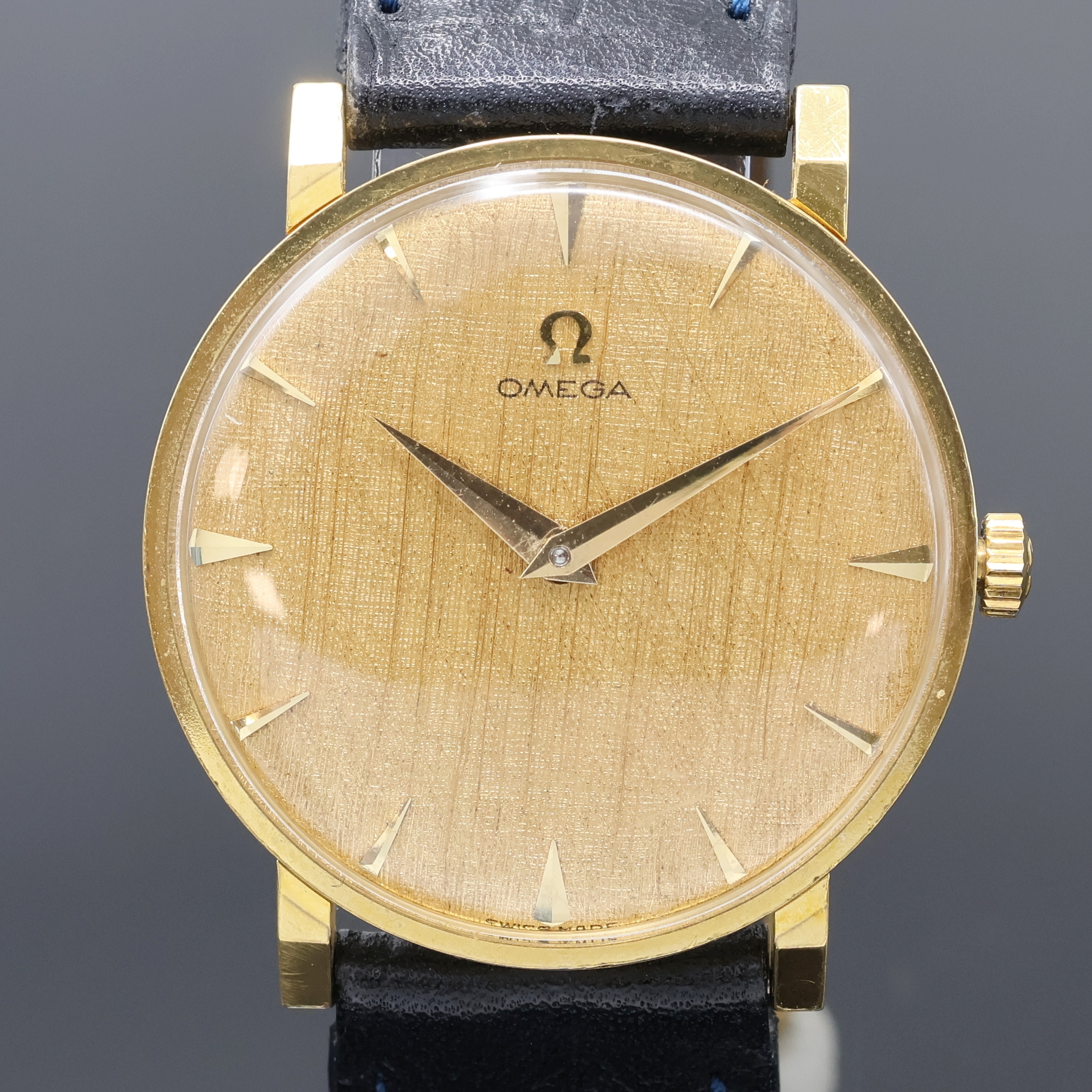 Detail a: OMEGA Armbanduhr in GG 750/000 Referenz 14372, Schweiz um 1960, Handaufzug, Boden aufgedr., strukt. goldfarb. Zifferbl. m. gold. Std.-Ind. u. Zeiger, ...